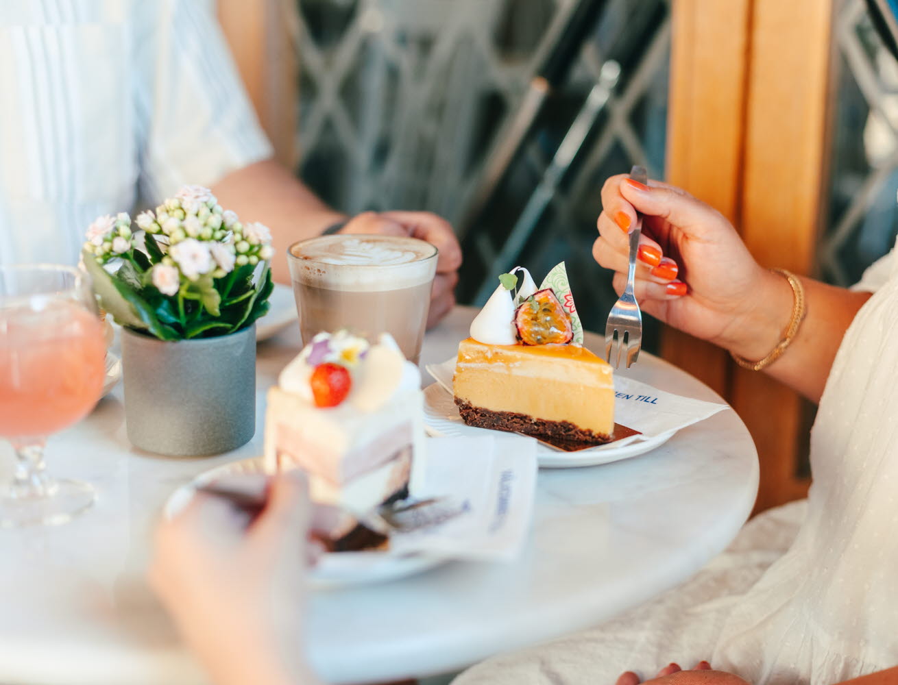 A young girl enjoying delicious pastries and drinks at Conditori Nordpolen