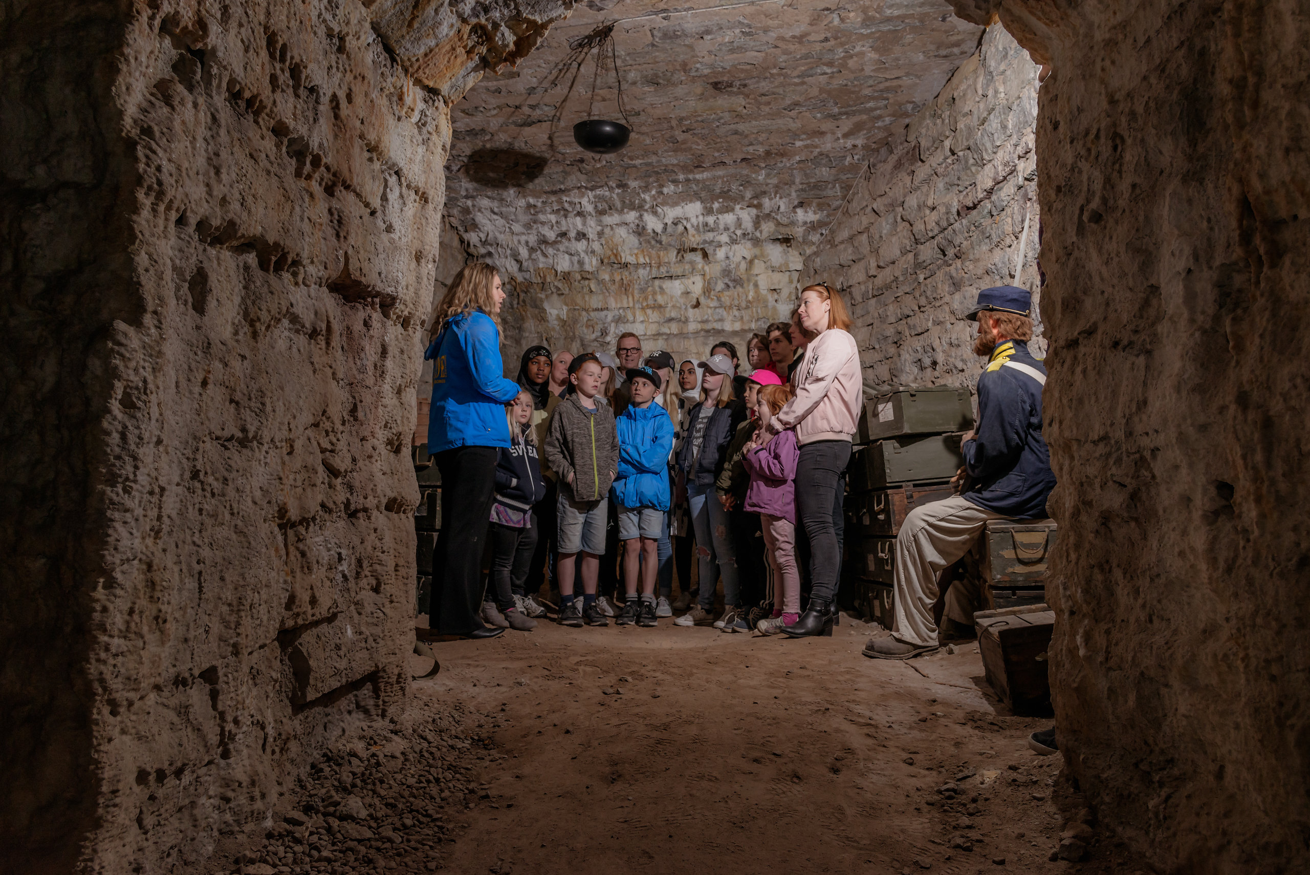 Guide talking to a group of people standing in an underground room.