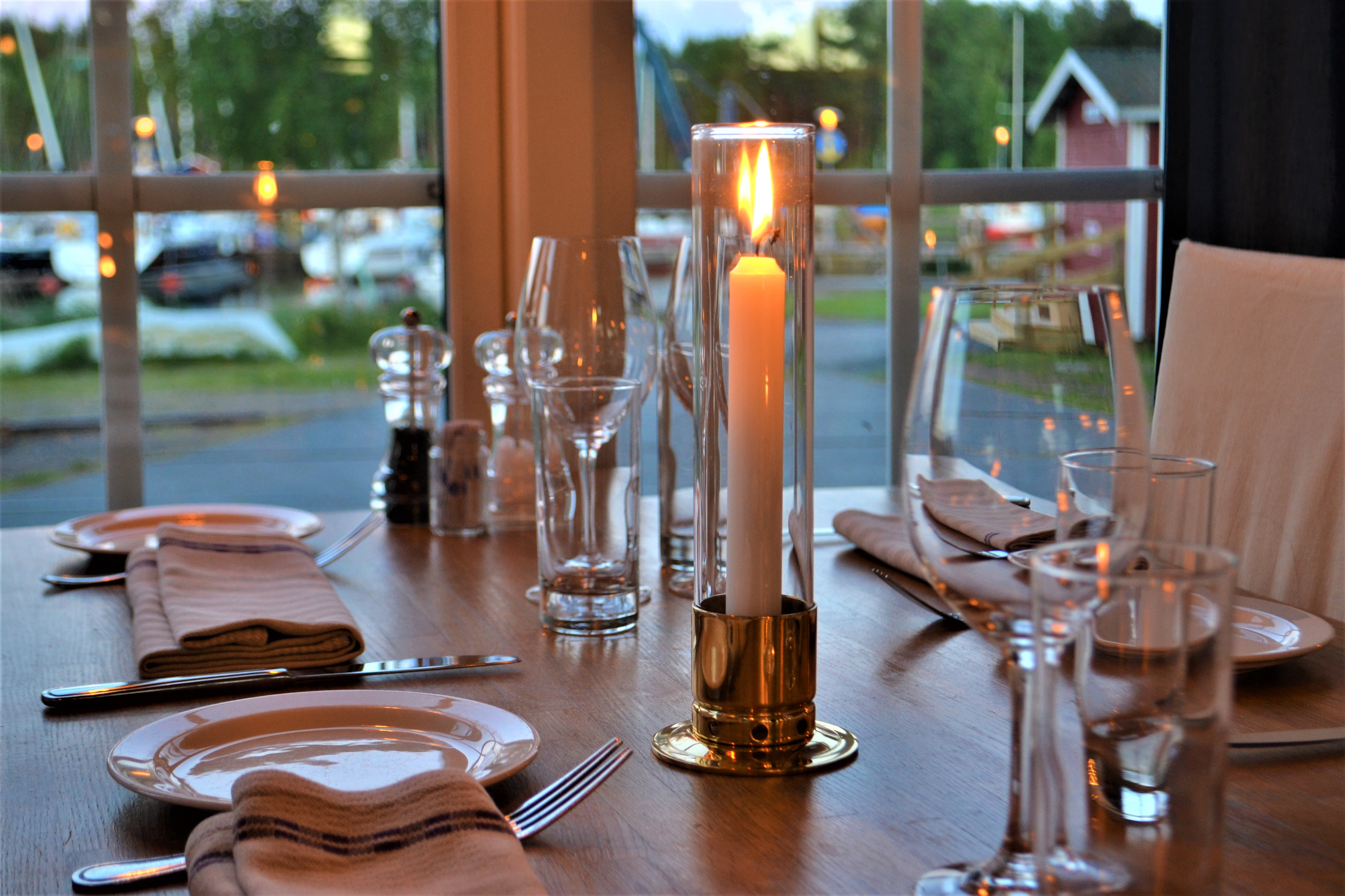 A set table next to a window in a restaurant.