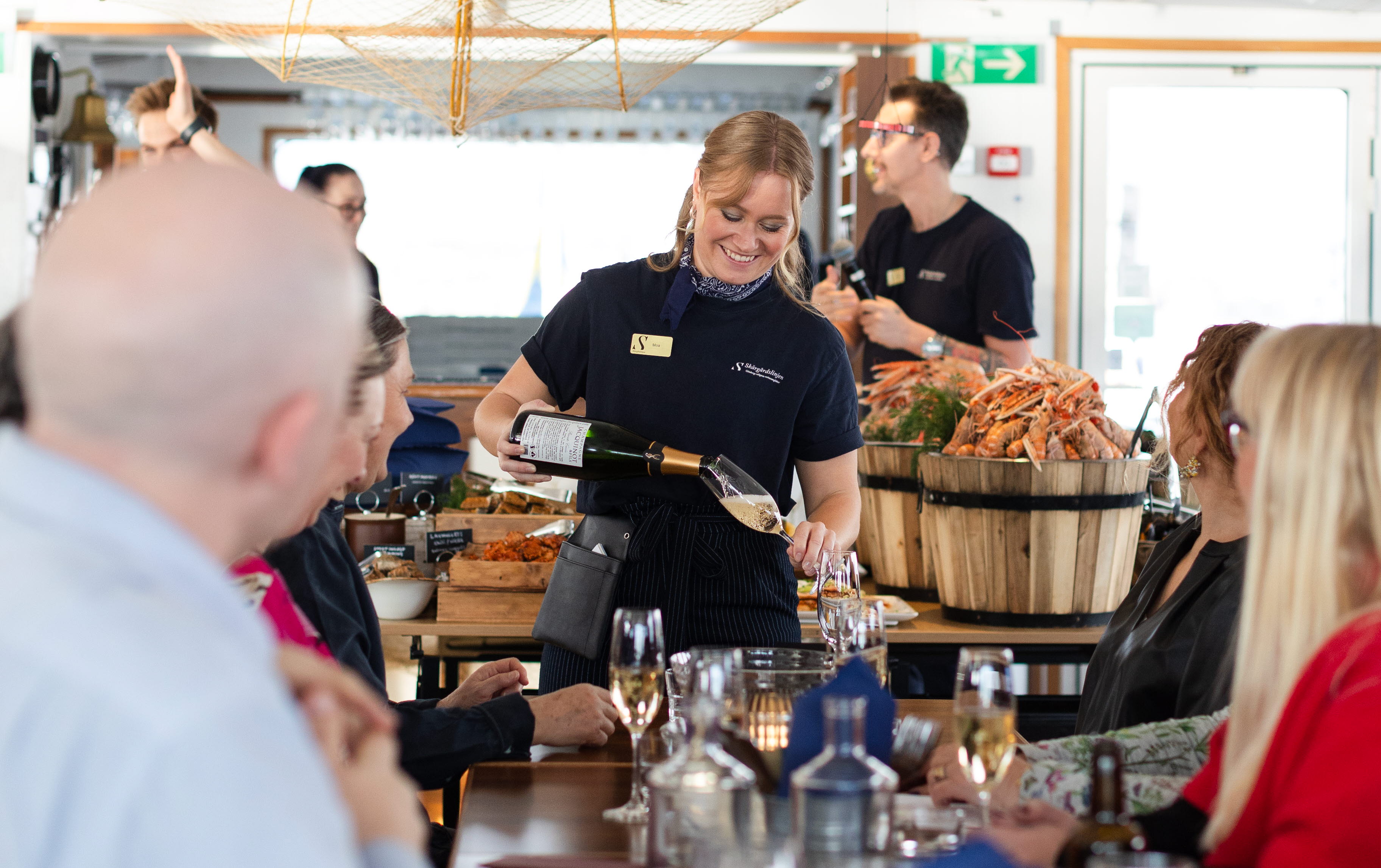 Happy woman serving wine on a boat.
