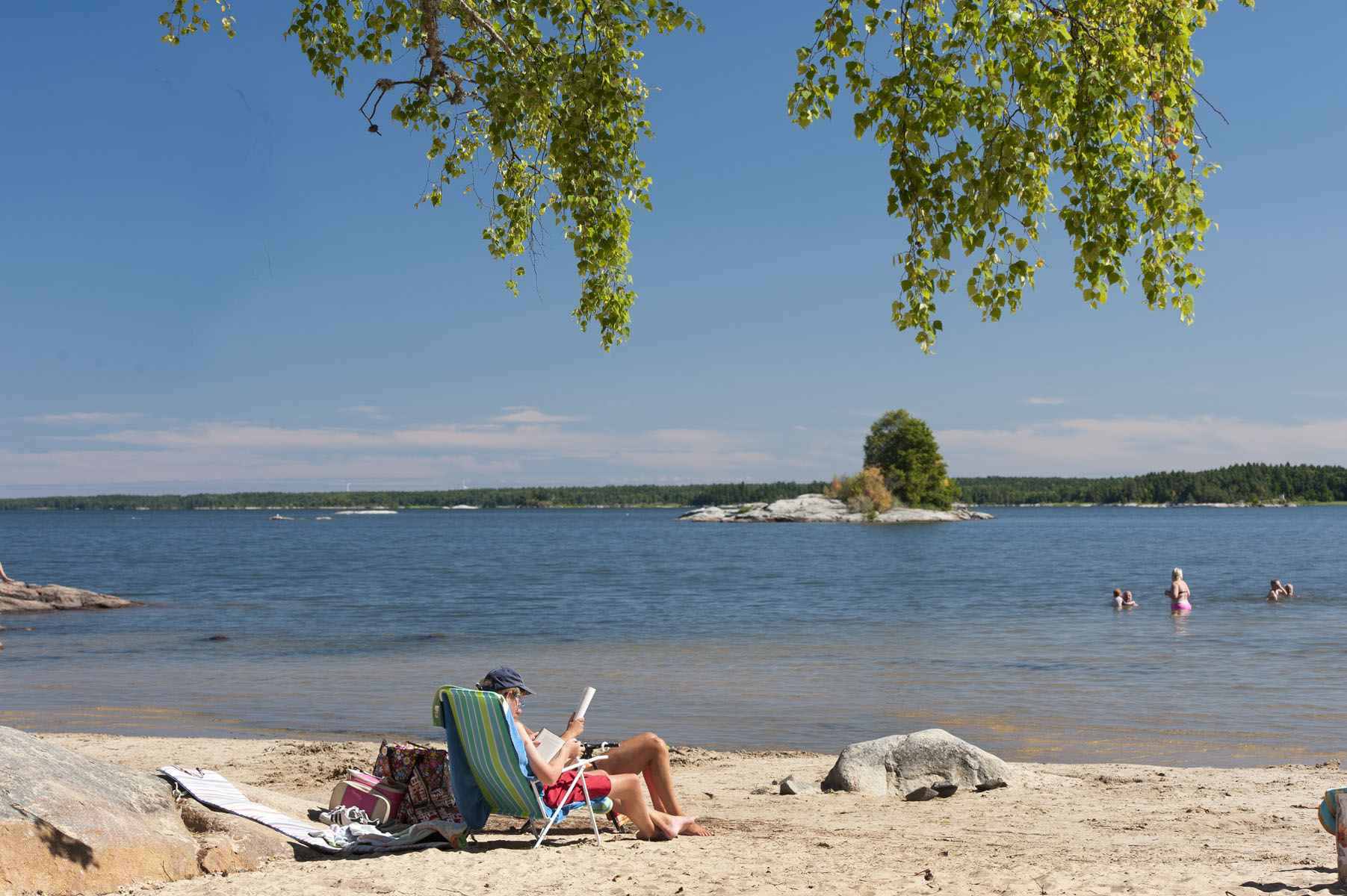 Two bikes standing next to a lake.