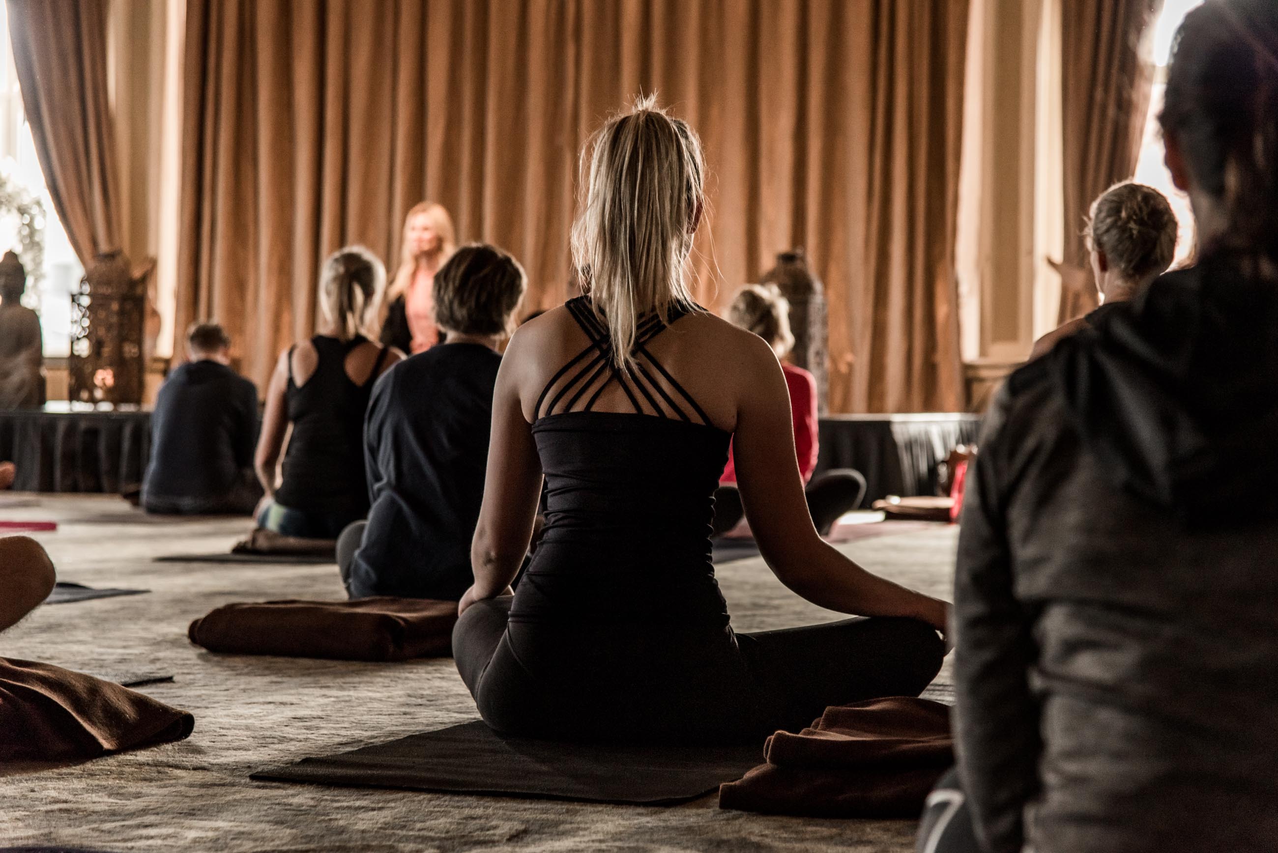 A dark yoga studio with people practicing yoga. 