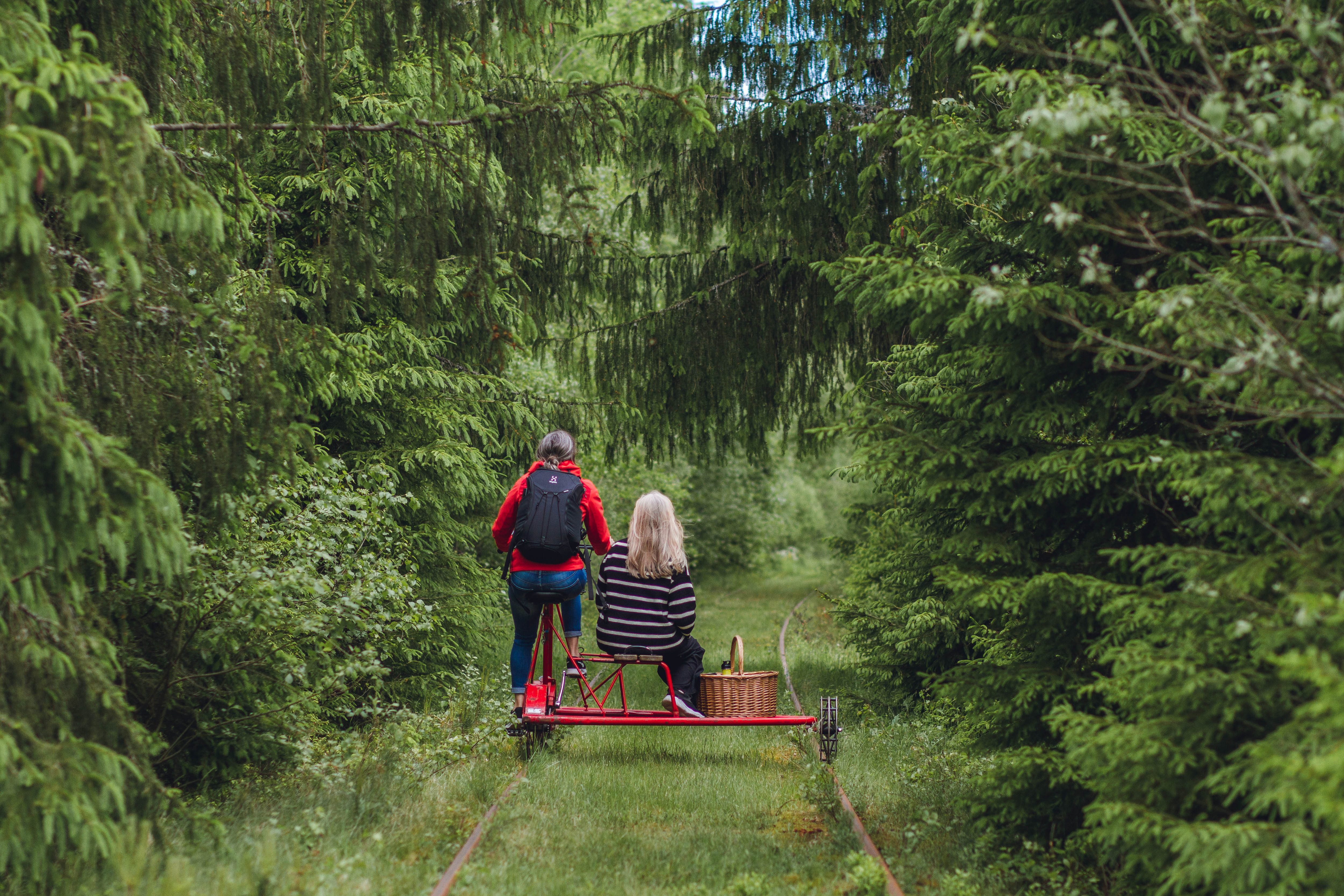Two people on a railway push trolley.