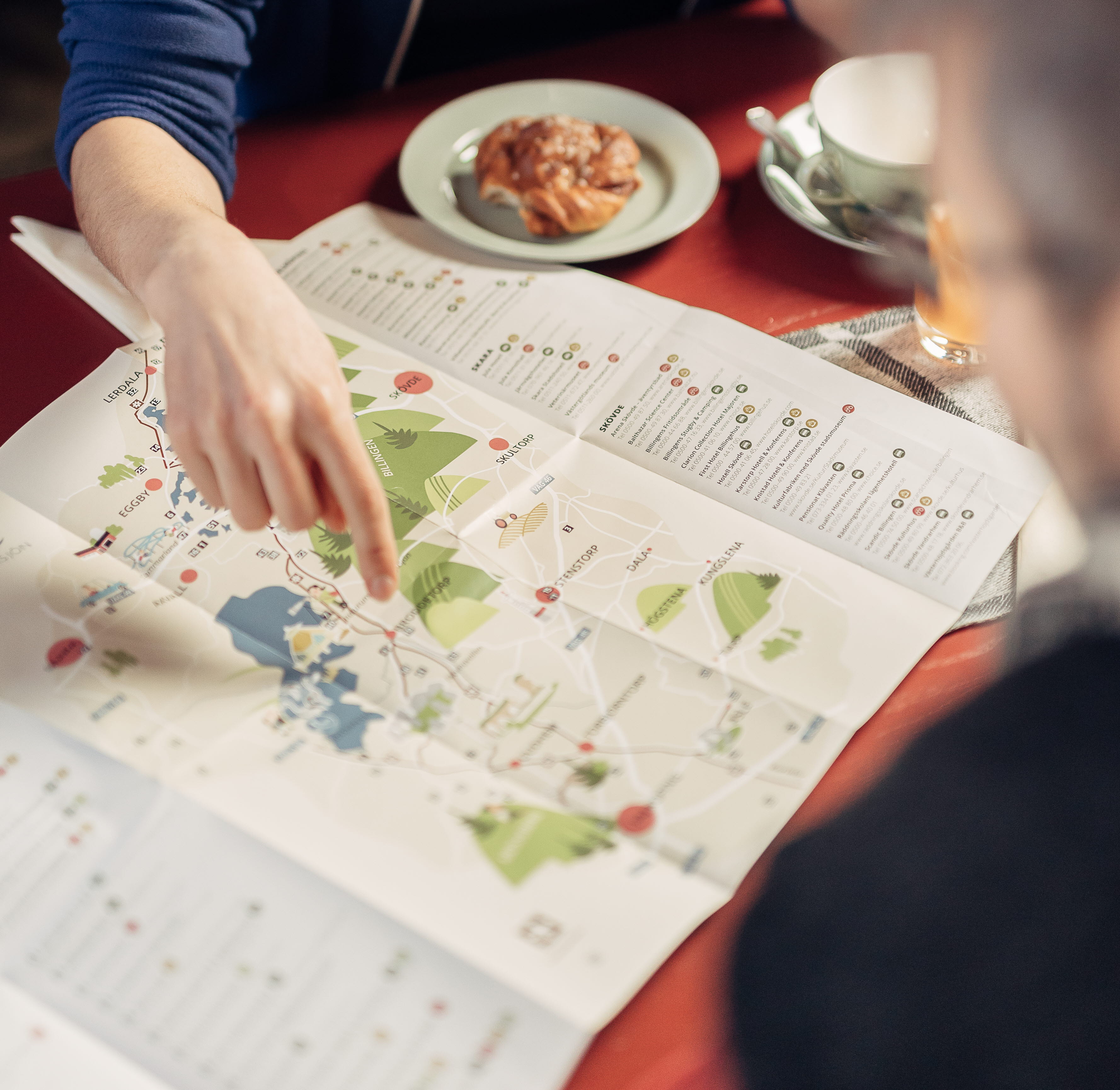 Two people plan their hike over a cup of coffee.