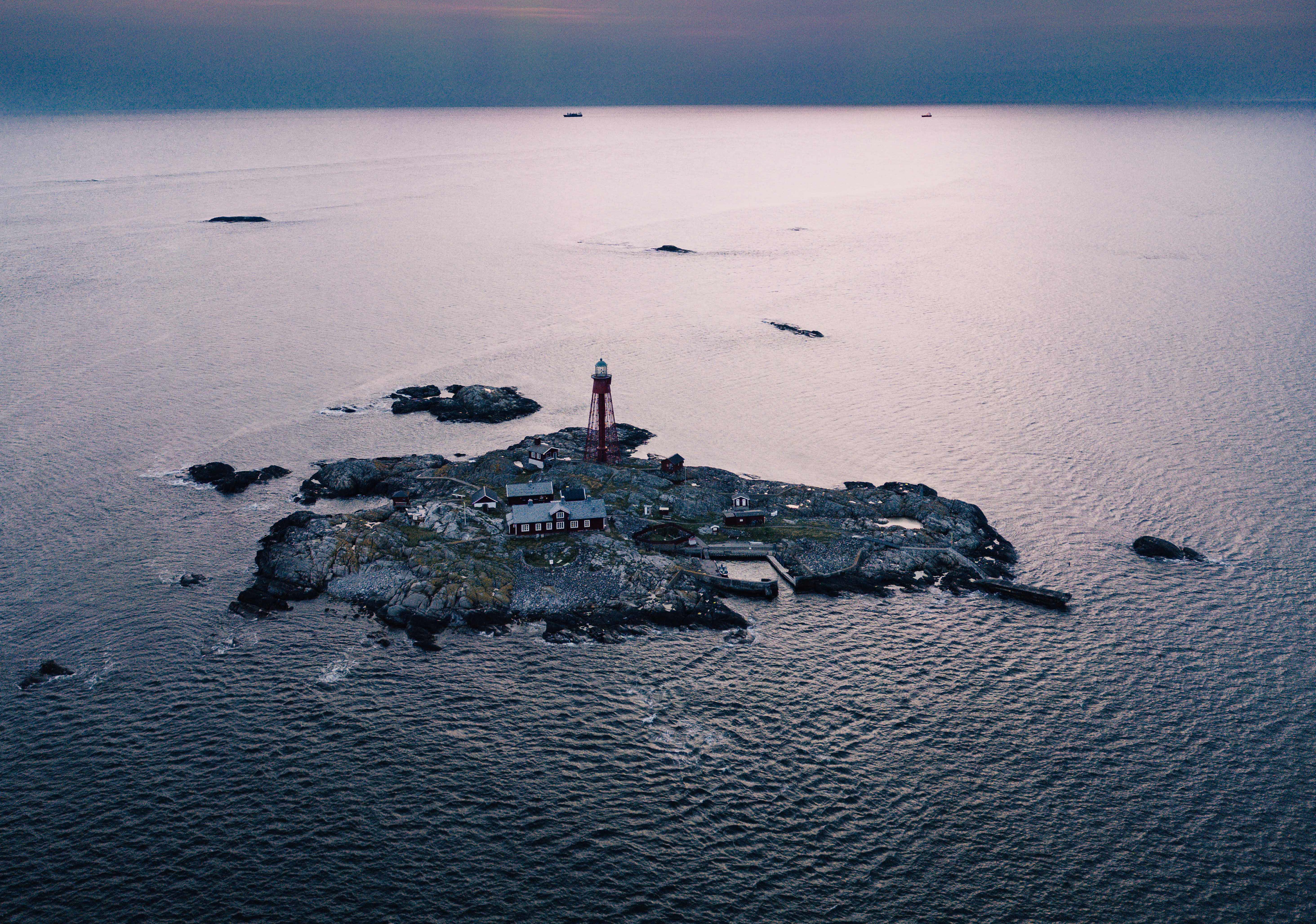 Aerial view over island with a lighthouse.