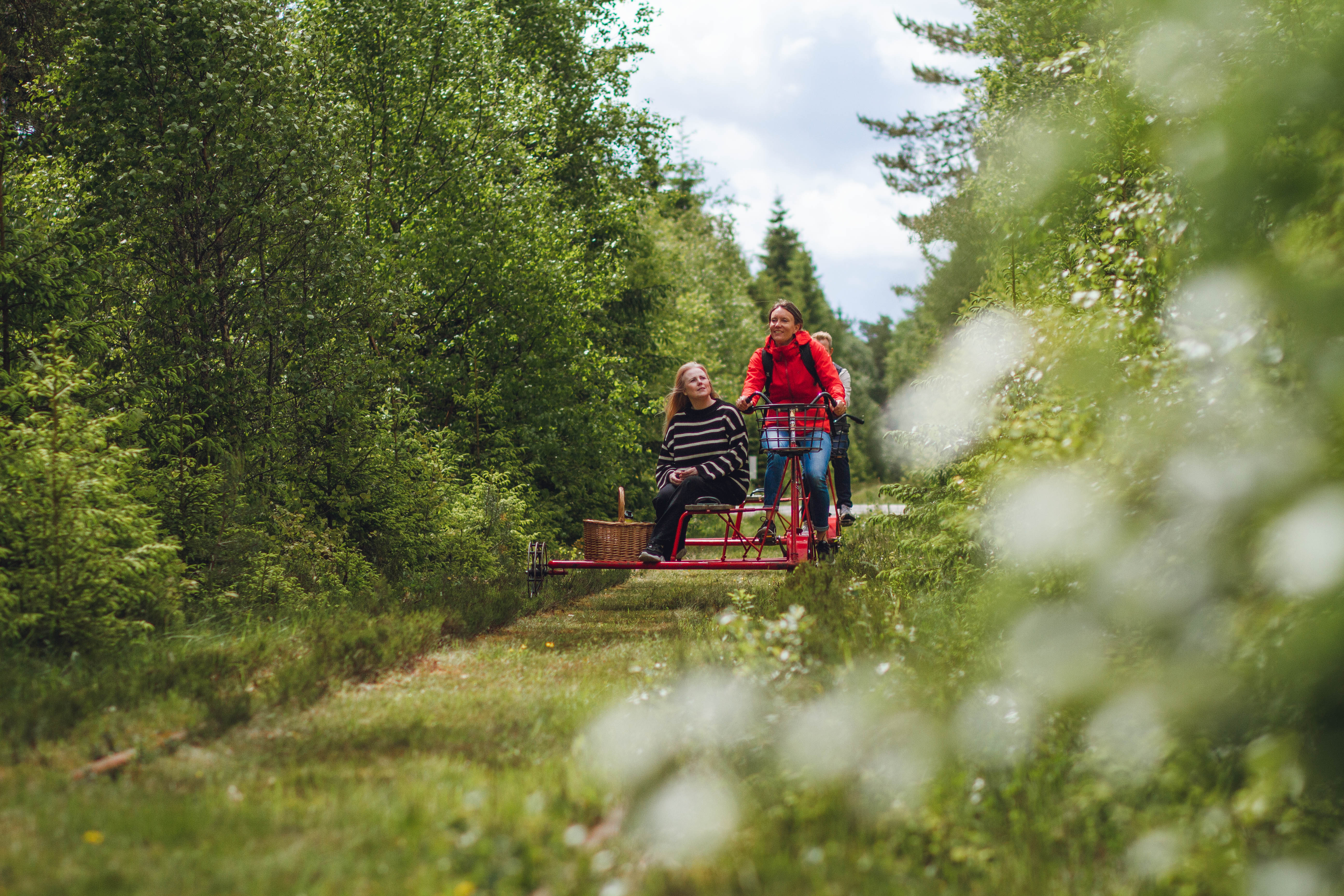 Two people on a railway push trolley.