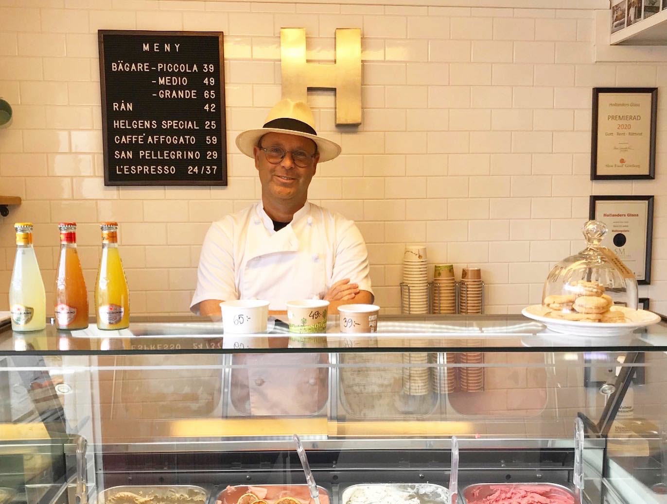 Joachim at Hollanders glass is standing behind a counter filled with ice cream, smiling at the camera