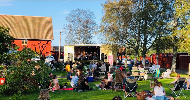 Crowd sitting in front of a music stage