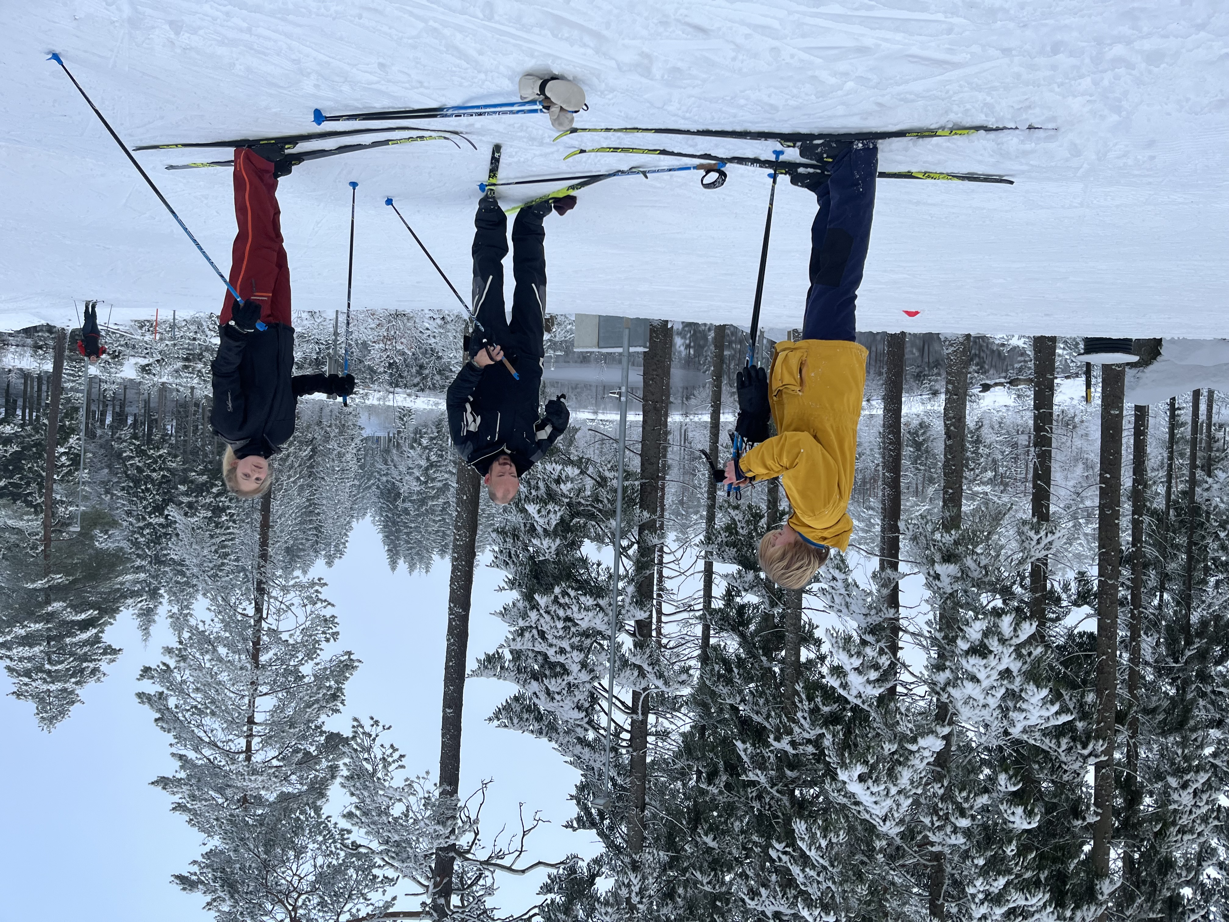 Family standing together on cross-country skis.
