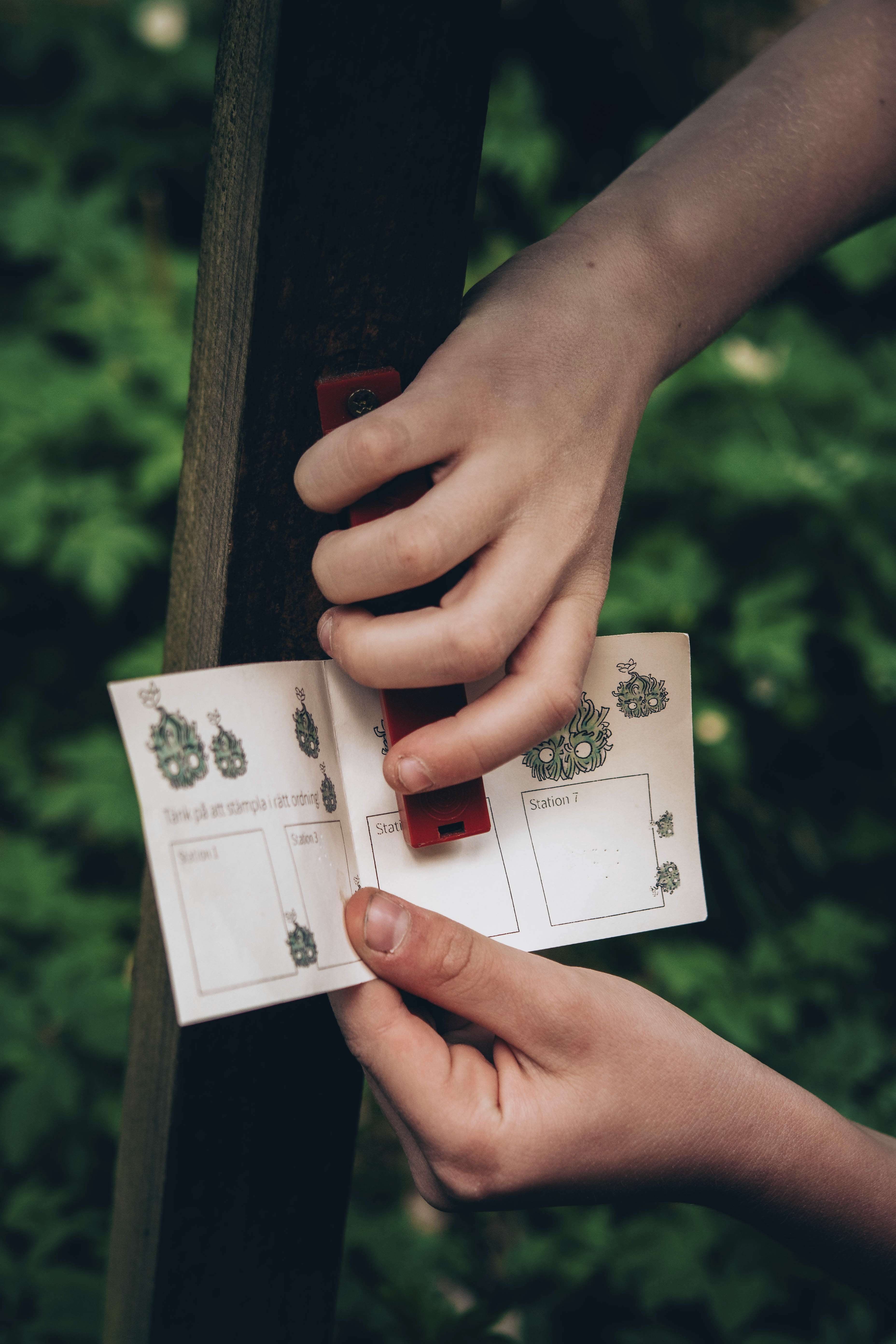Hands stamping an orientation pass (along Billingetroll's wizard path)