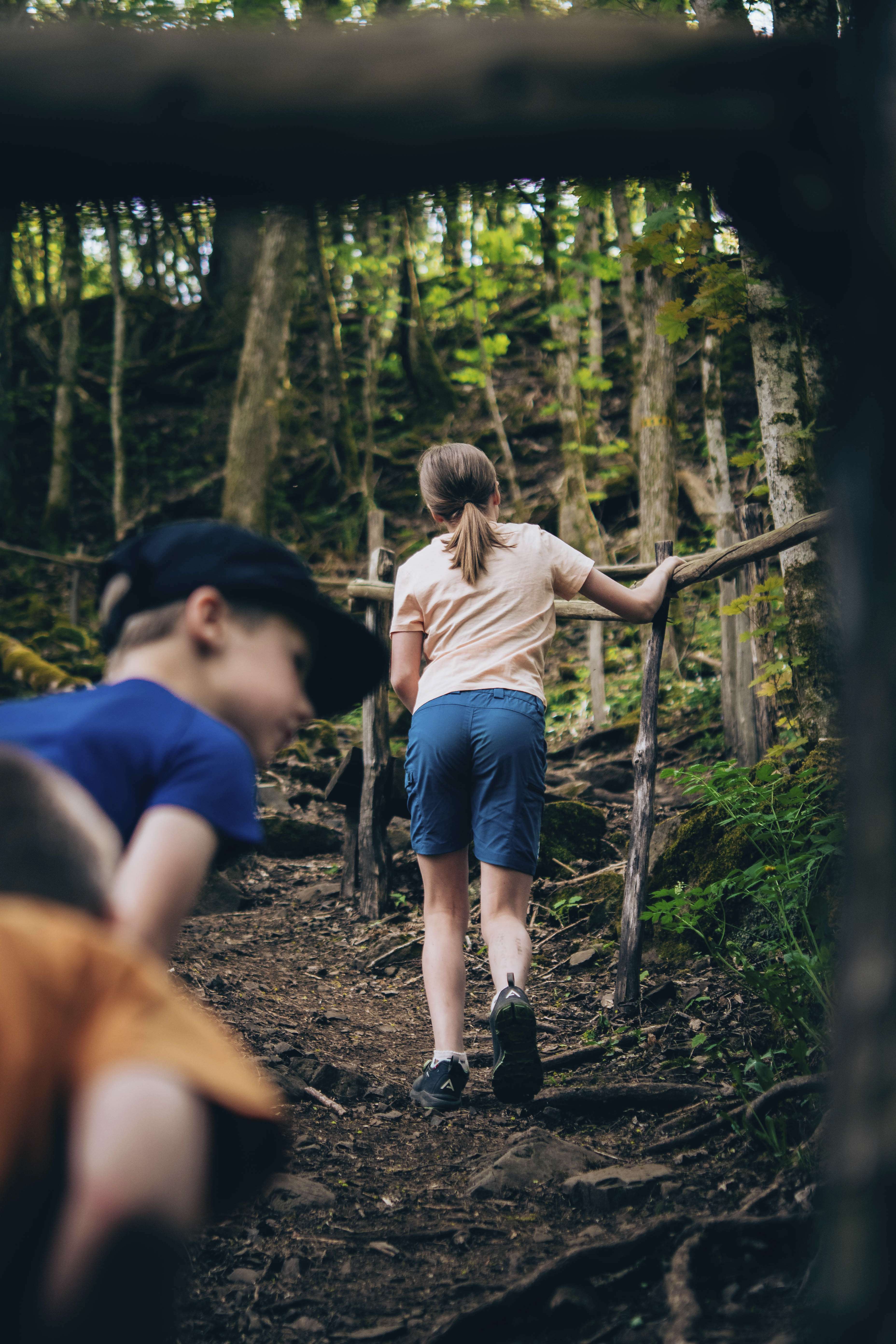 Children walking up a steep path in the forest