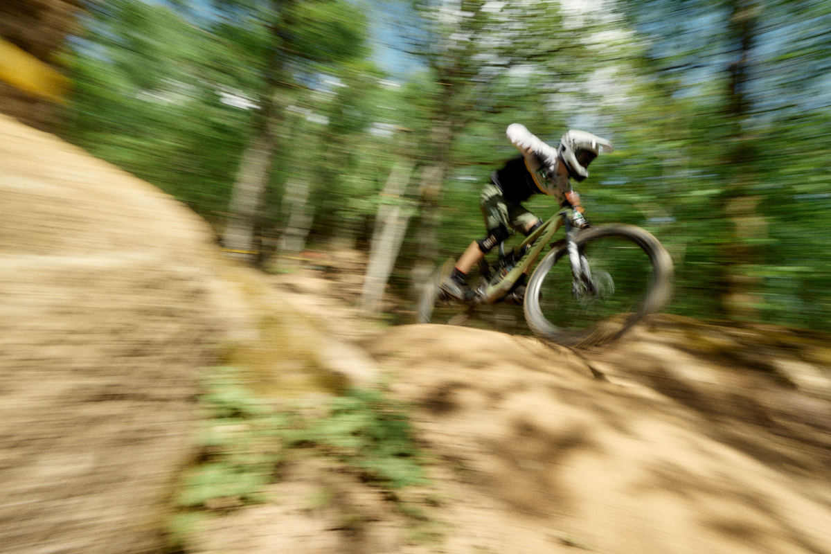 A person is riding down a steep gravel bike trail.