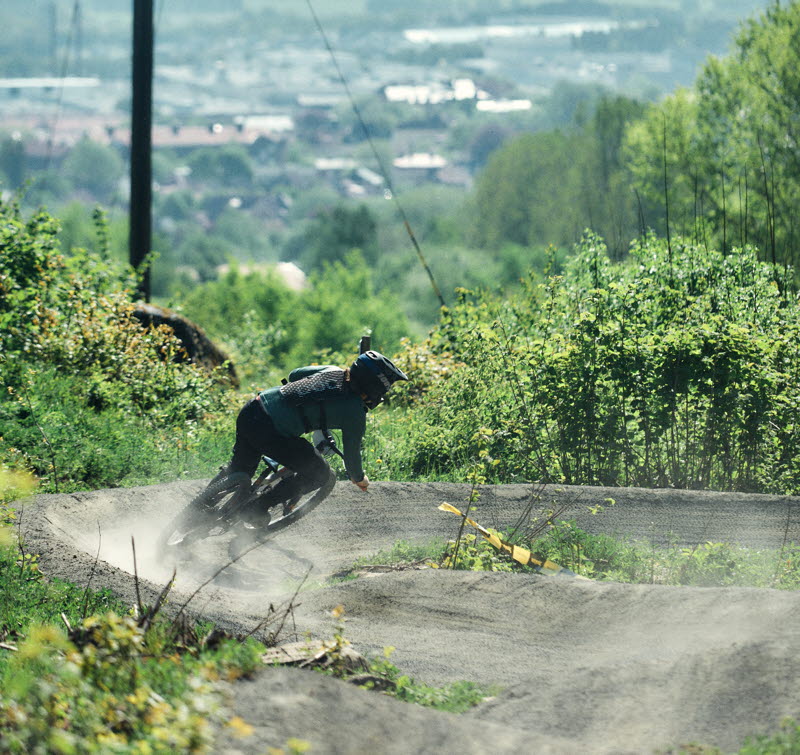 A person is riding down a steep gravel bike trail.