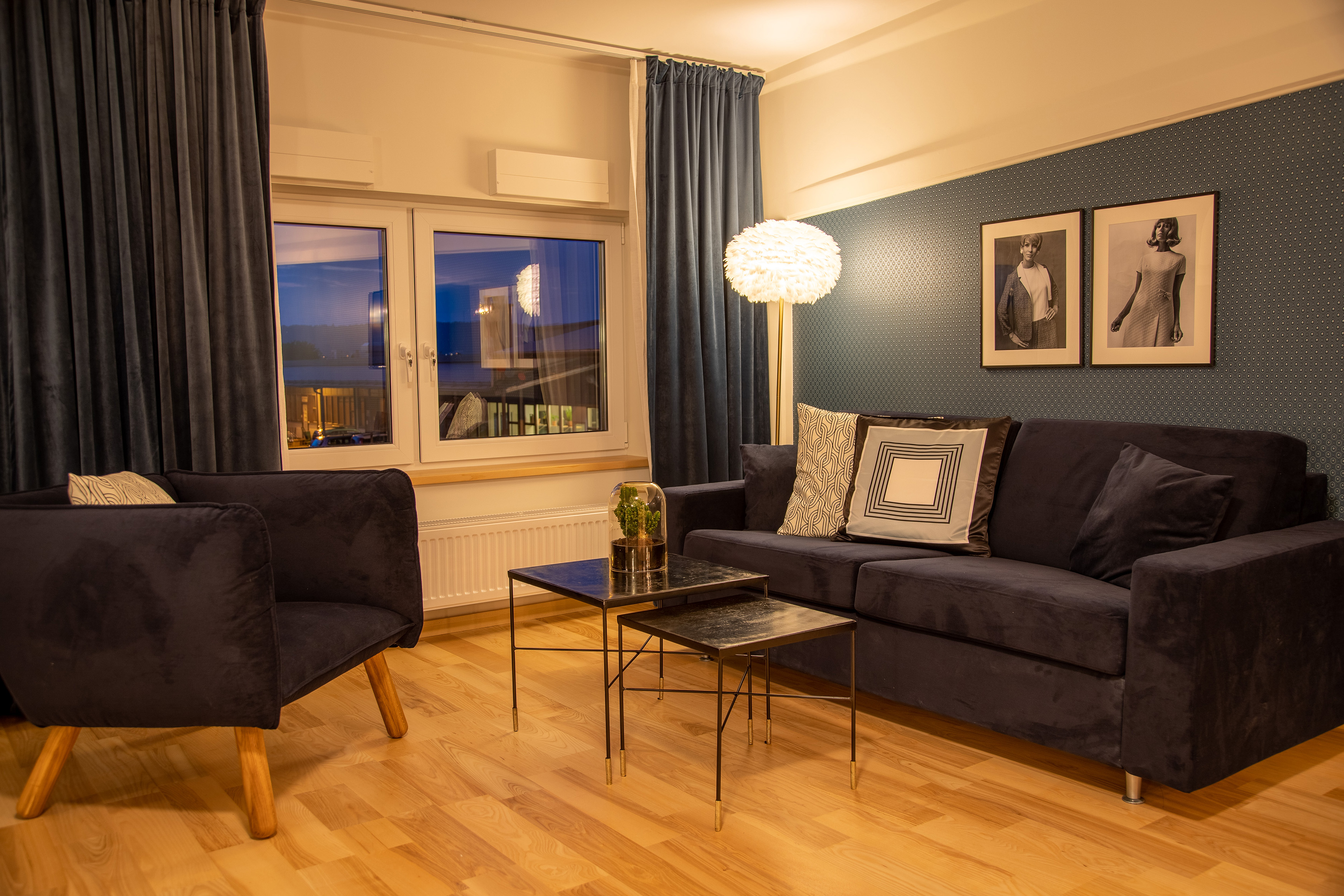 Family room with blue sofa and armchair. Blue wallpaper and curtains.