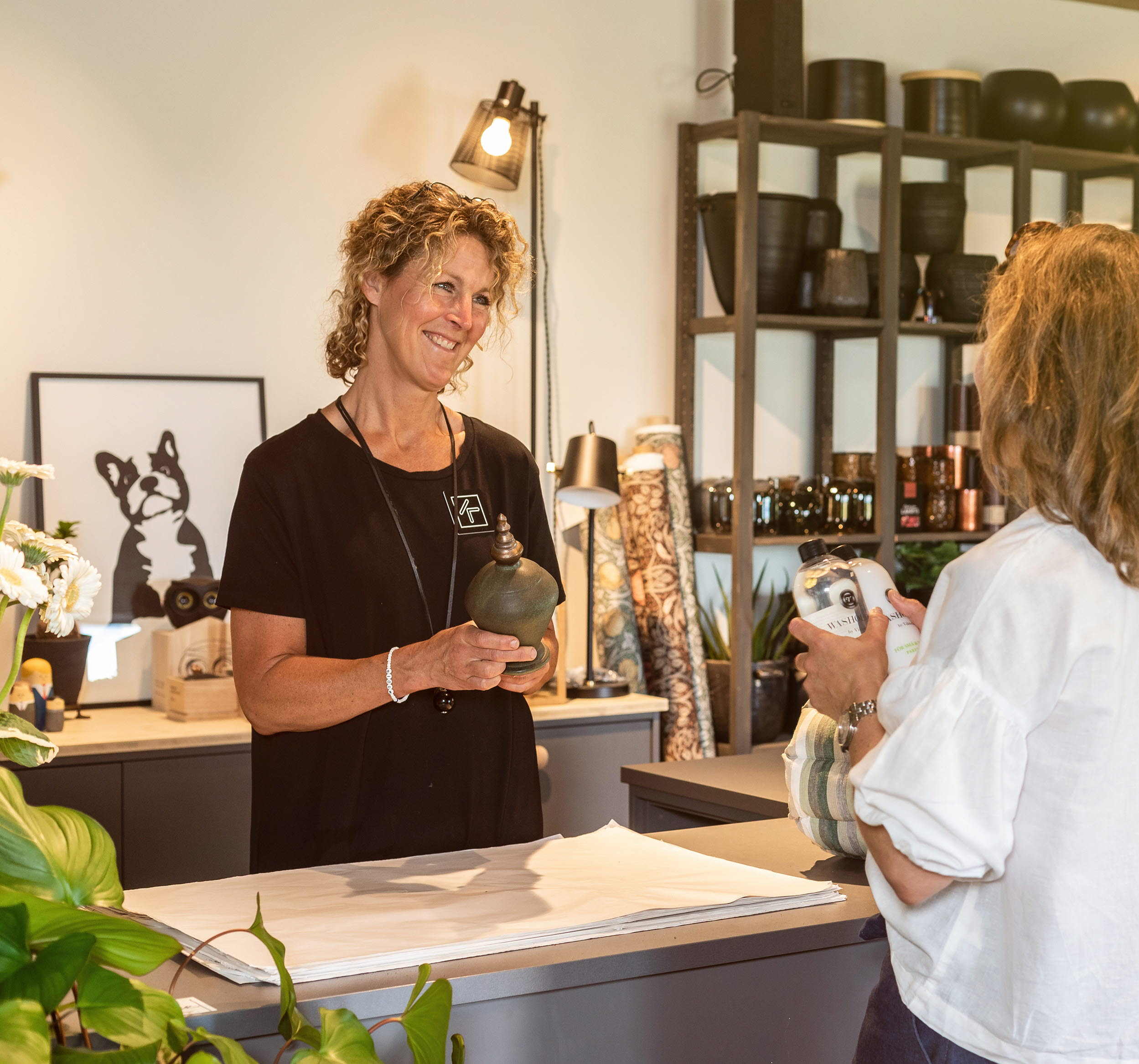 Two women shopping for interior design by the store owner.