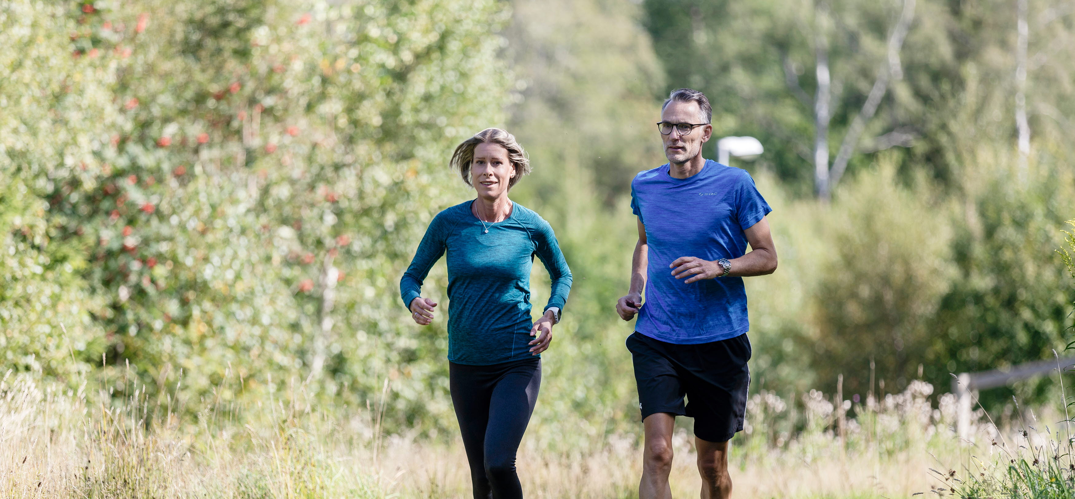 Woman and man running in an exercise track.