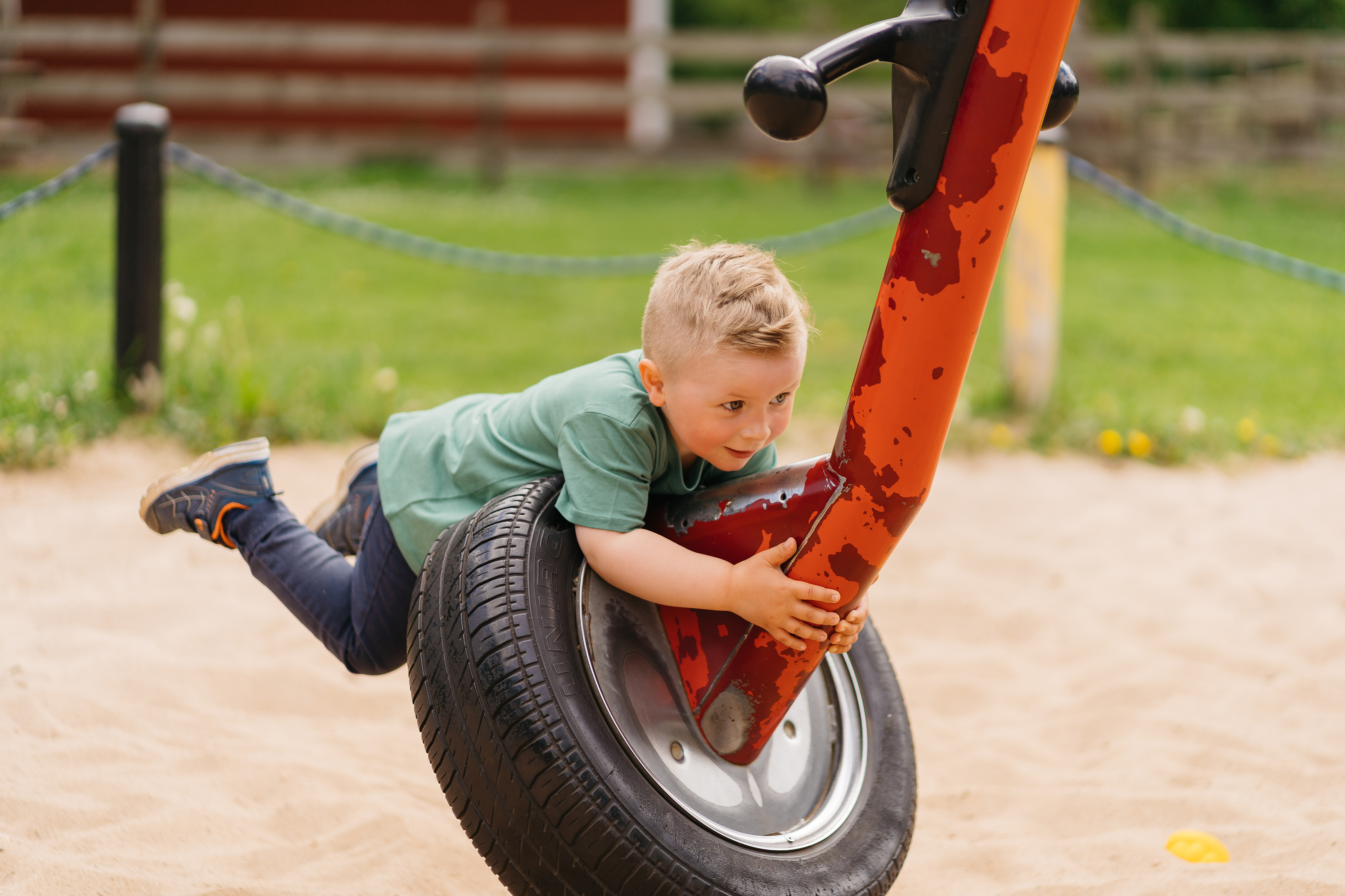 Boy hanging on belly over a toy.