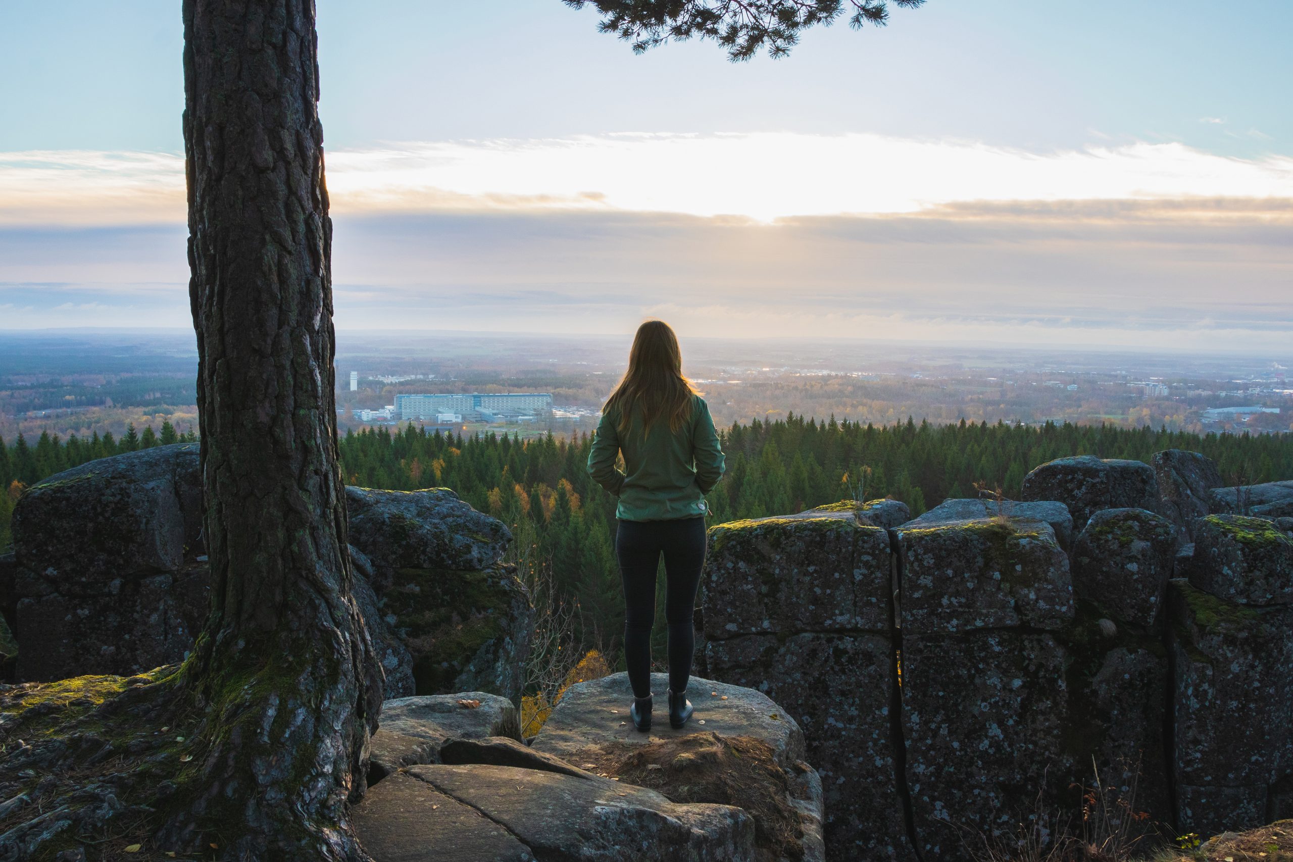 Woman standing with her back to the camera and looking out over a beautiful view.