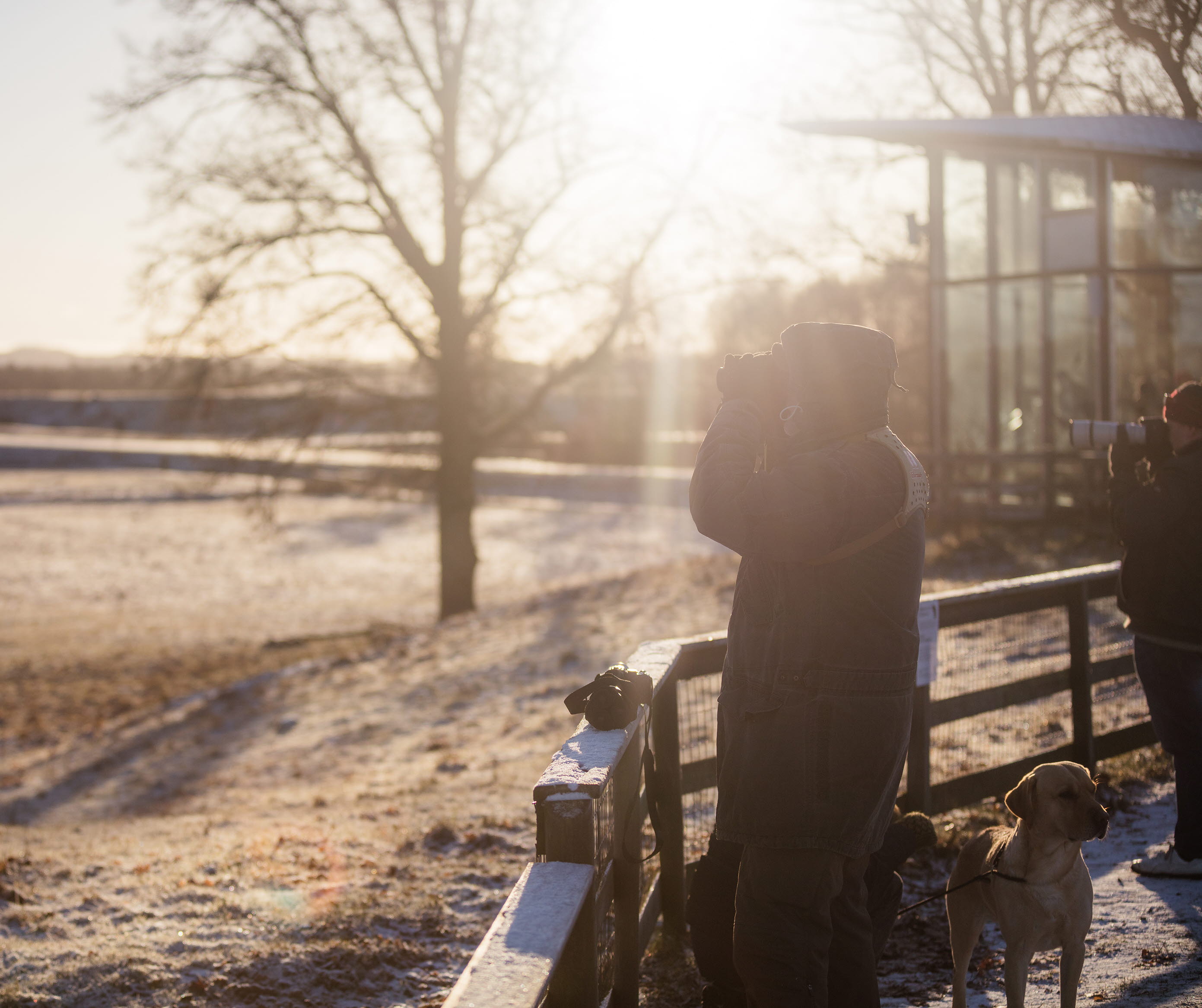 Man standing with binoculars and looking out from Trandansen's information center.