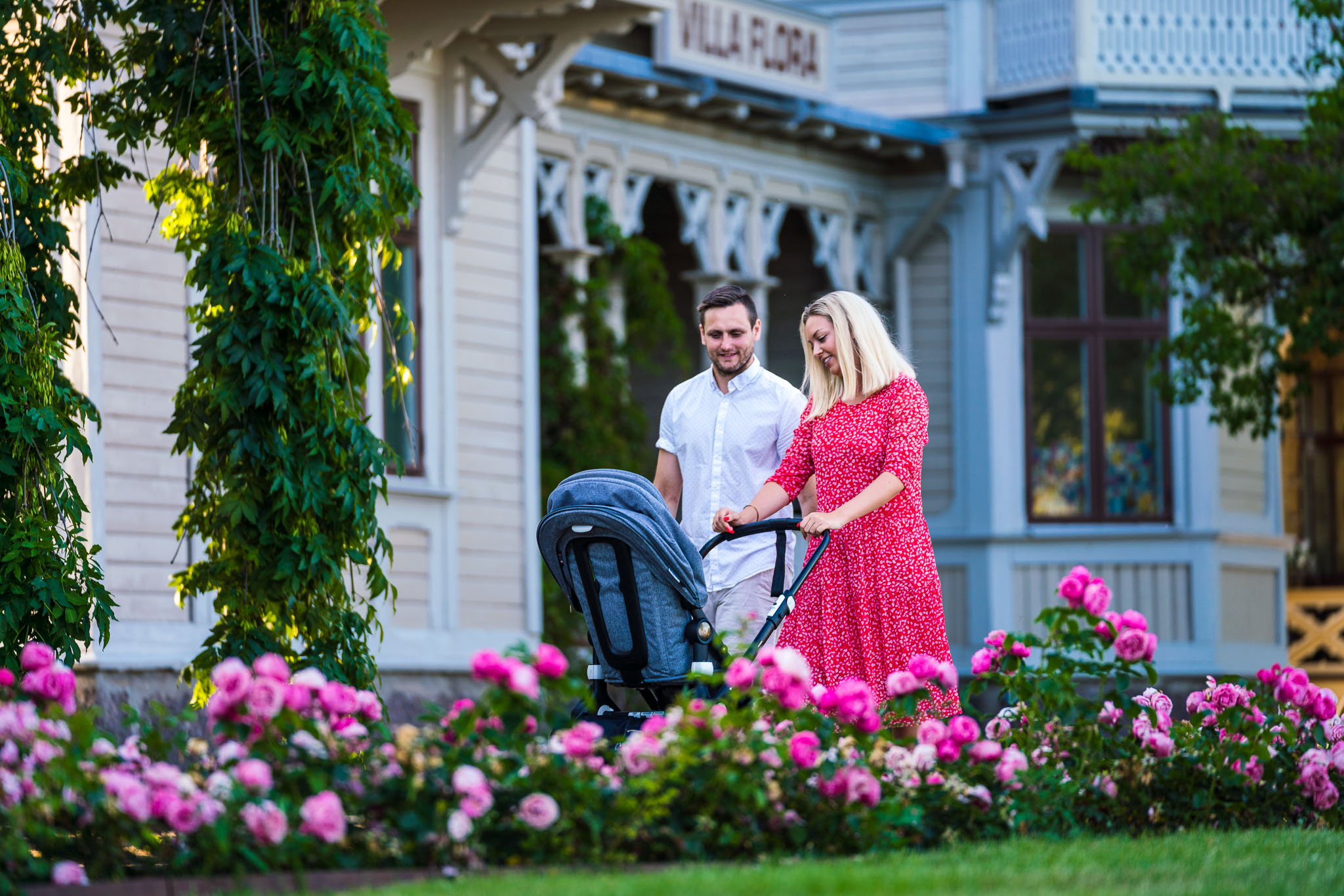 Couple with baby trolley walking in the town park in Hjo. 