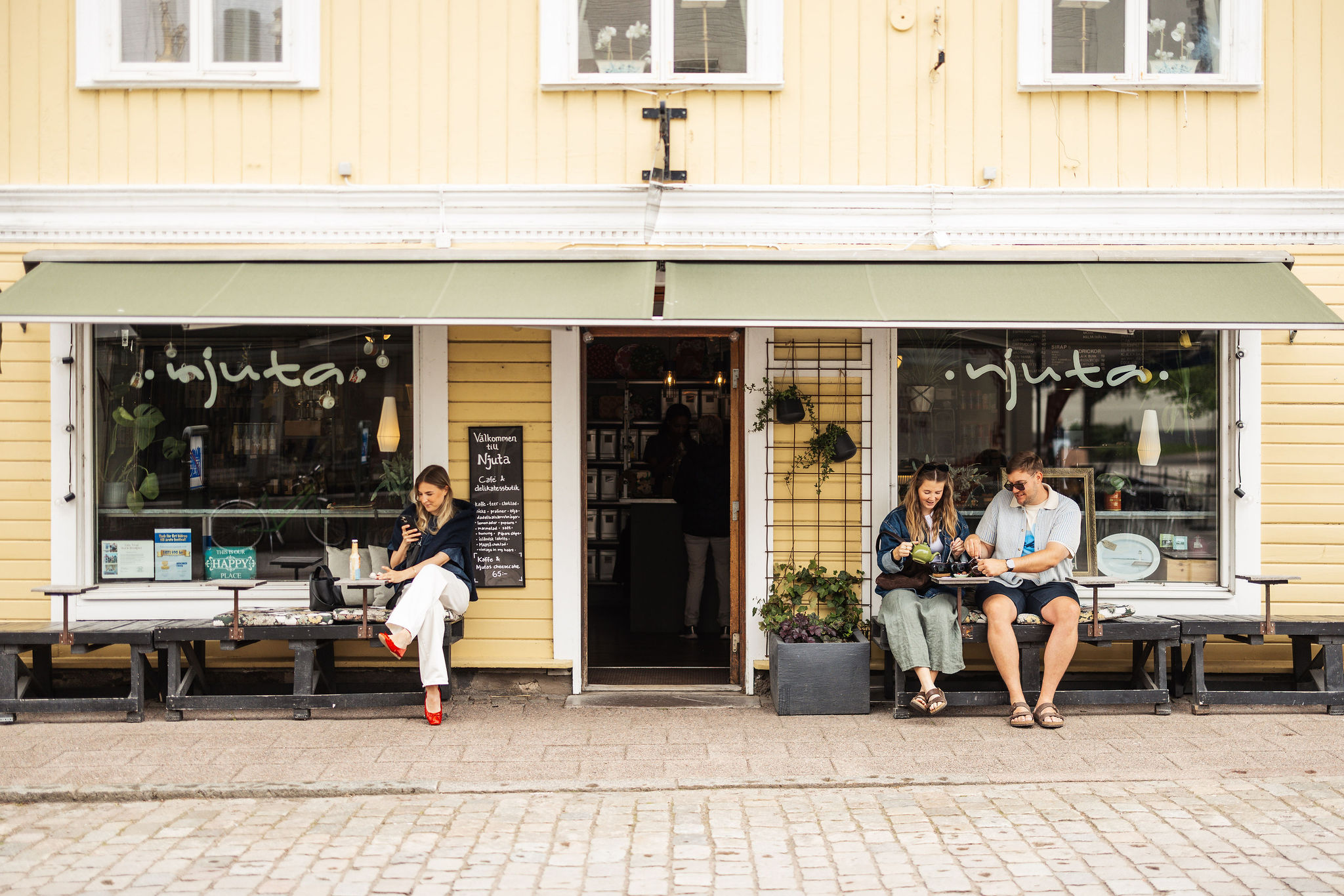 A group of people enjoying Hjo together with food, drinks, coffee and some shopping