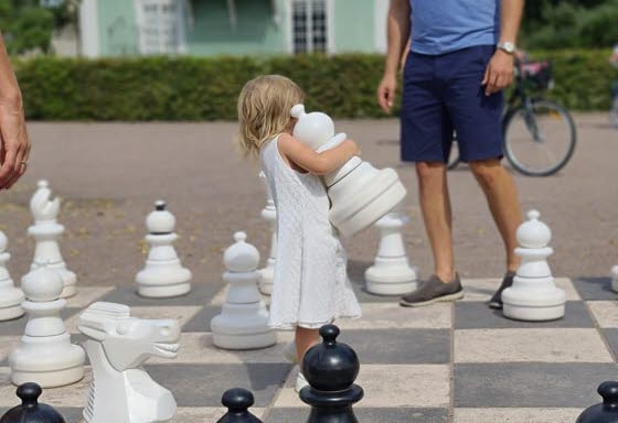 Little girl playing outdoor chess. 