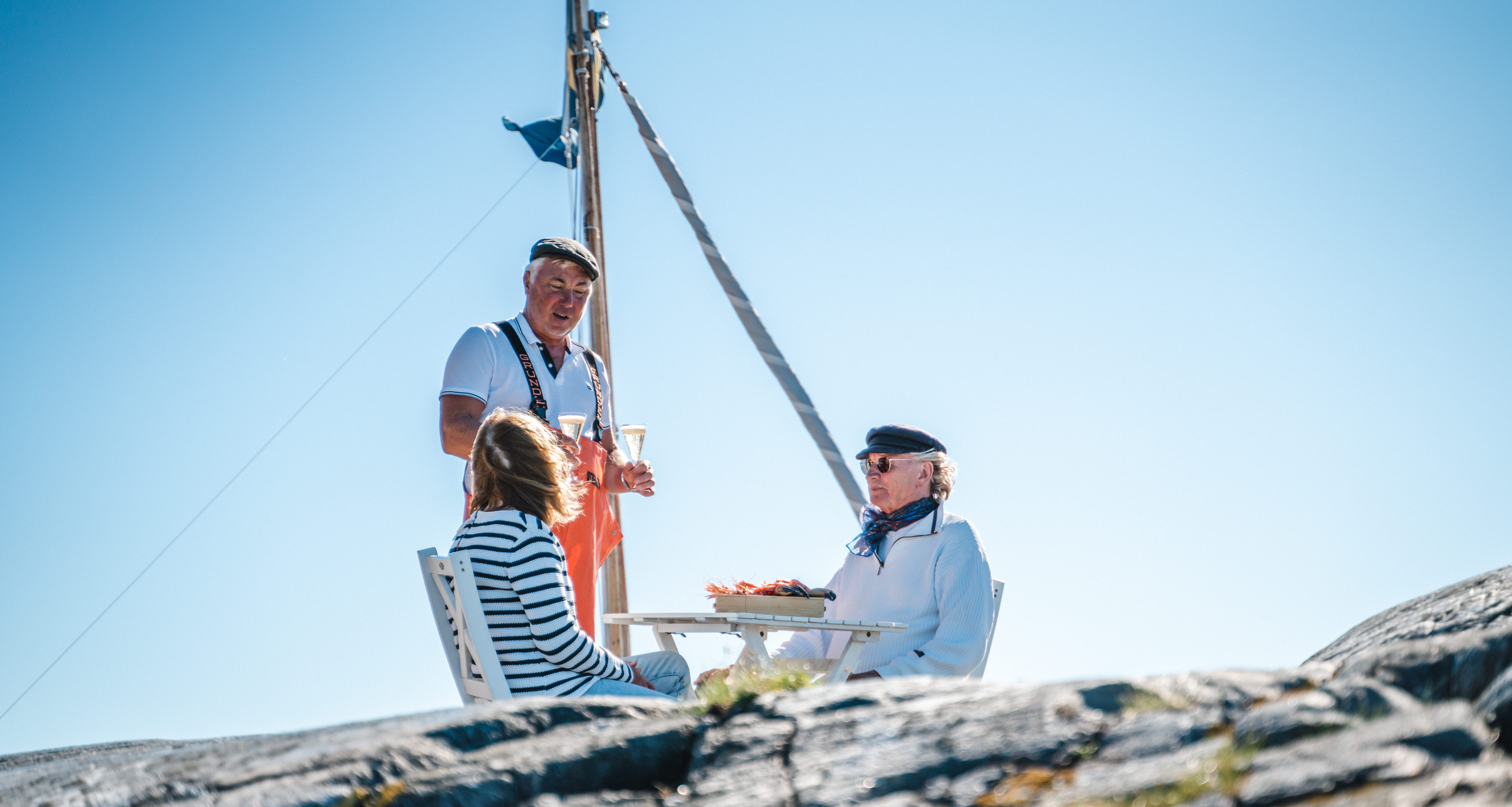 Two women sit and wait for the train at a red booth.