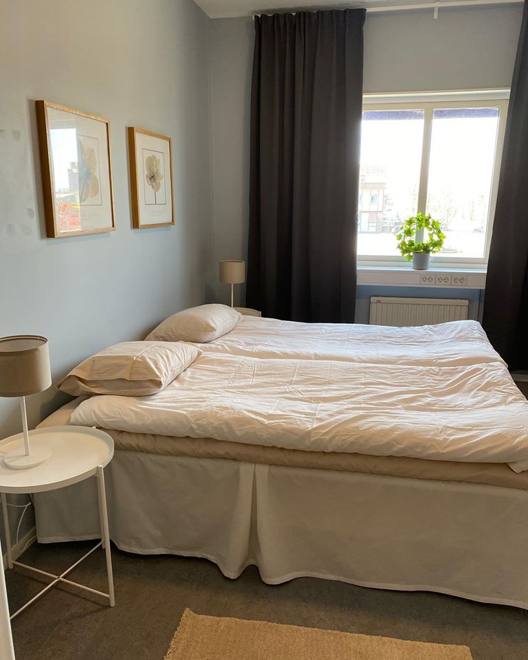 One double bed, paintings on the walls and two bedside tables next to the beds.