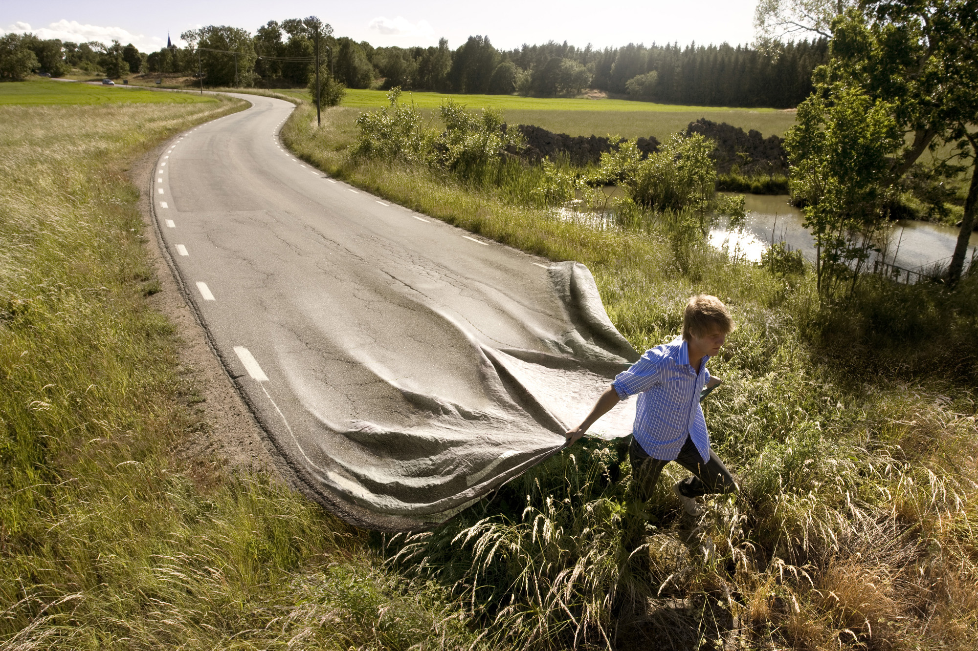 Surreal photo where a man draga a road behind him