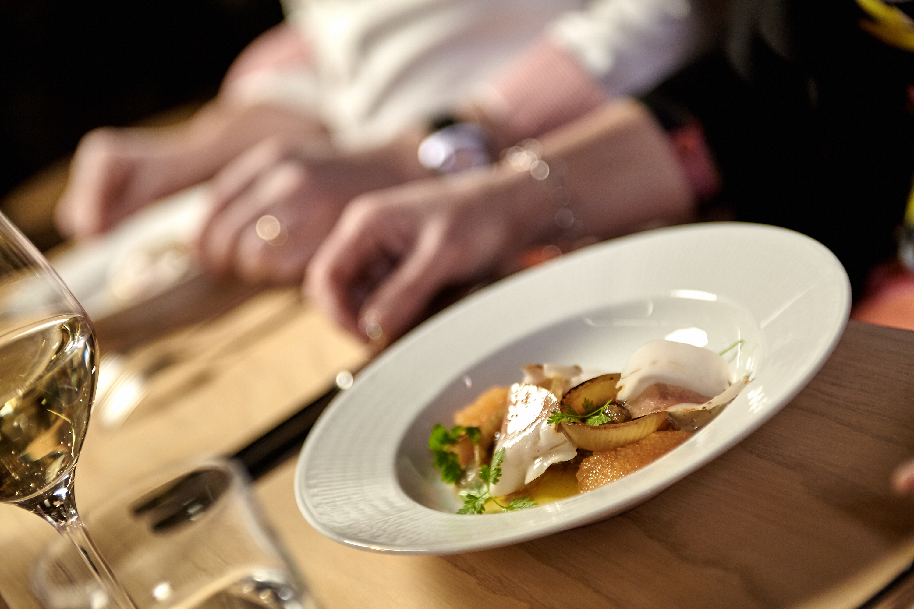 Two women stand on a golf green on a sunny summer day.