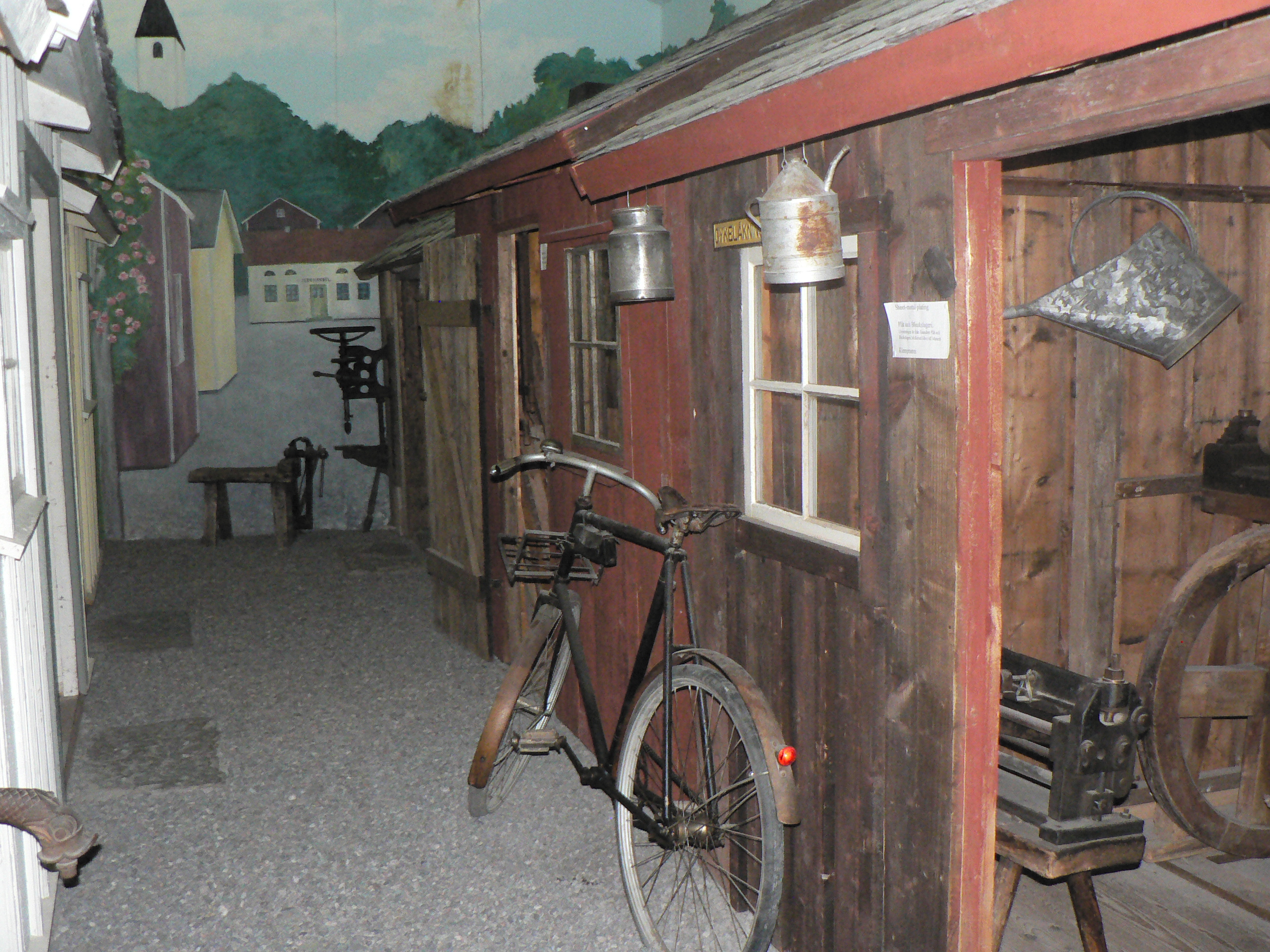 Woman holding a black bowl with a dragonfly in it. The hands are black from forging.