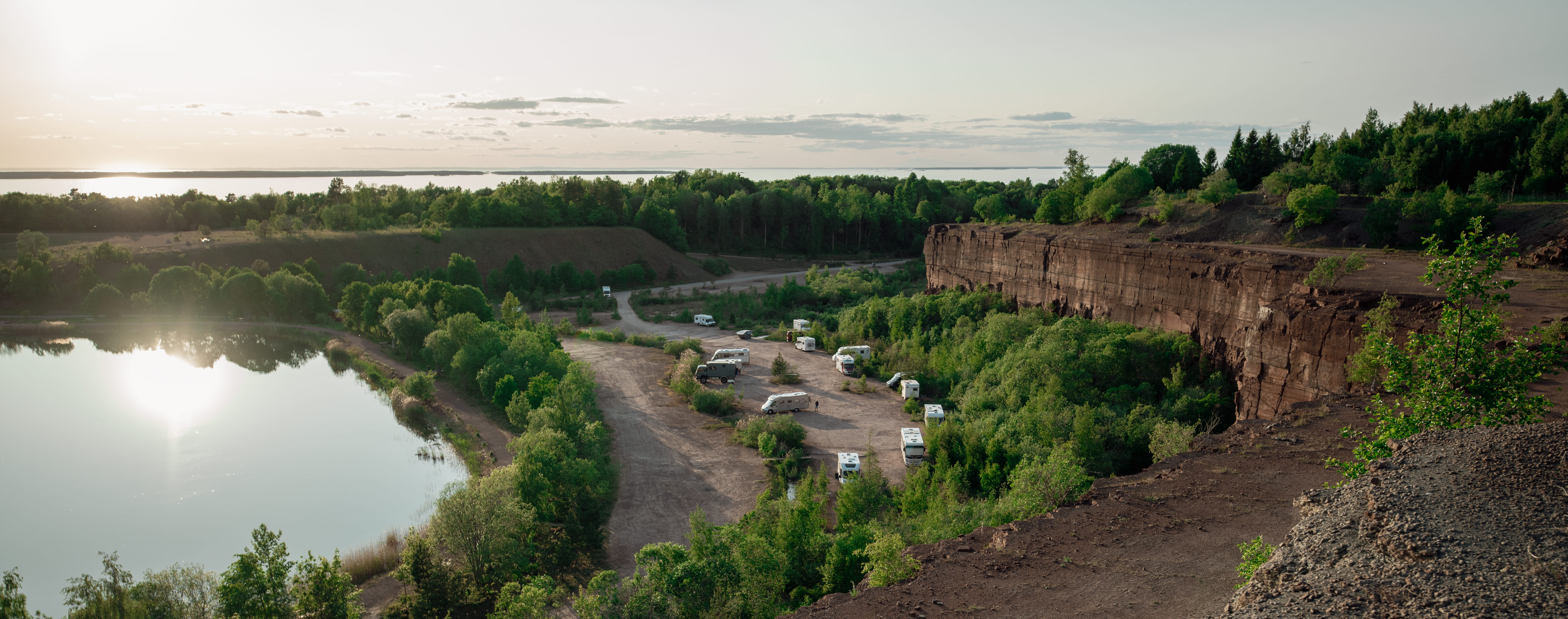 Three people walking at Stora Stenbrottet at Kinnekulle with views of Lake Vänern