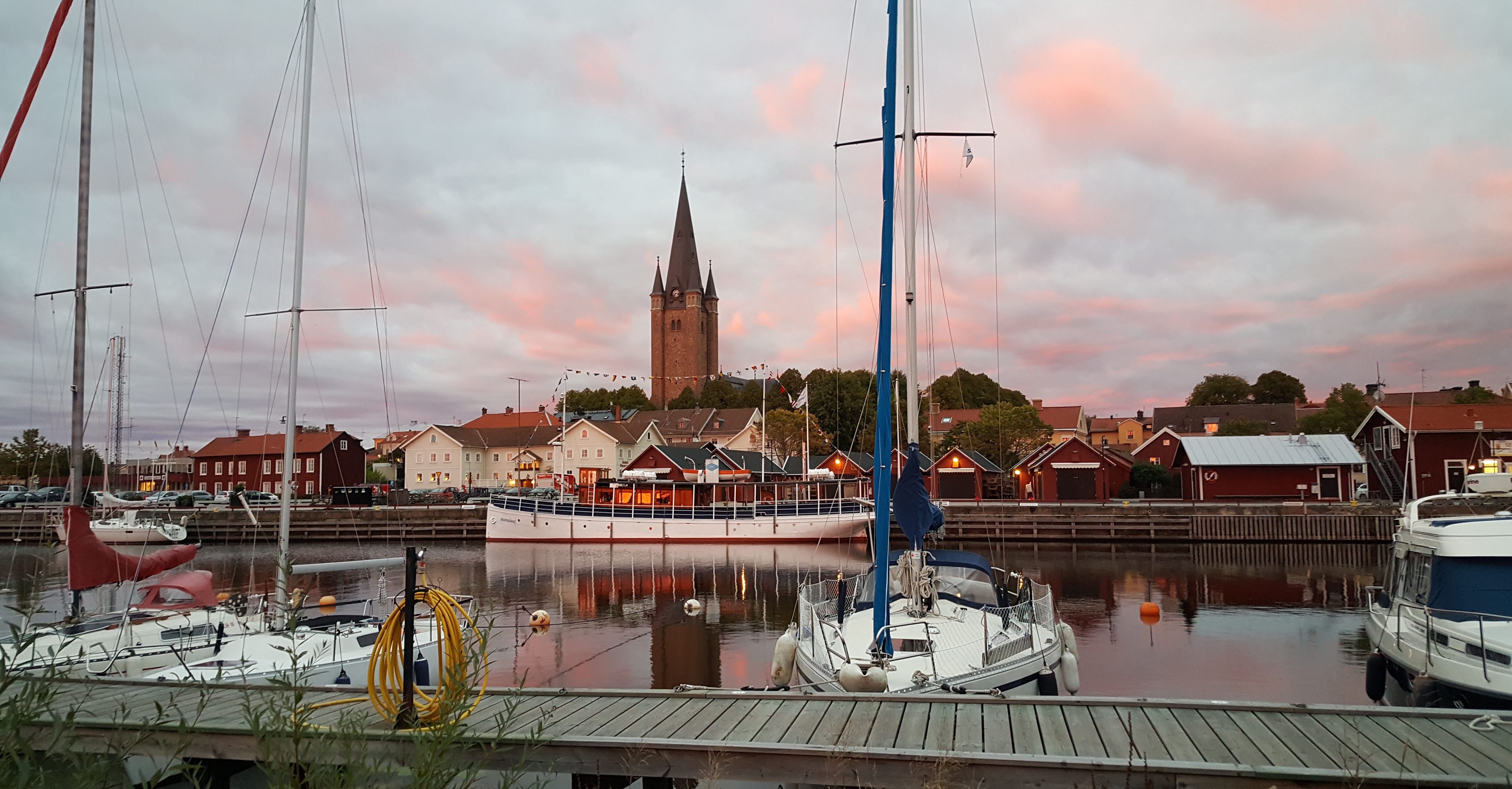 Sunset with a few boats in the harbor in Mariestad, the Old Town and the cathedral in the background.