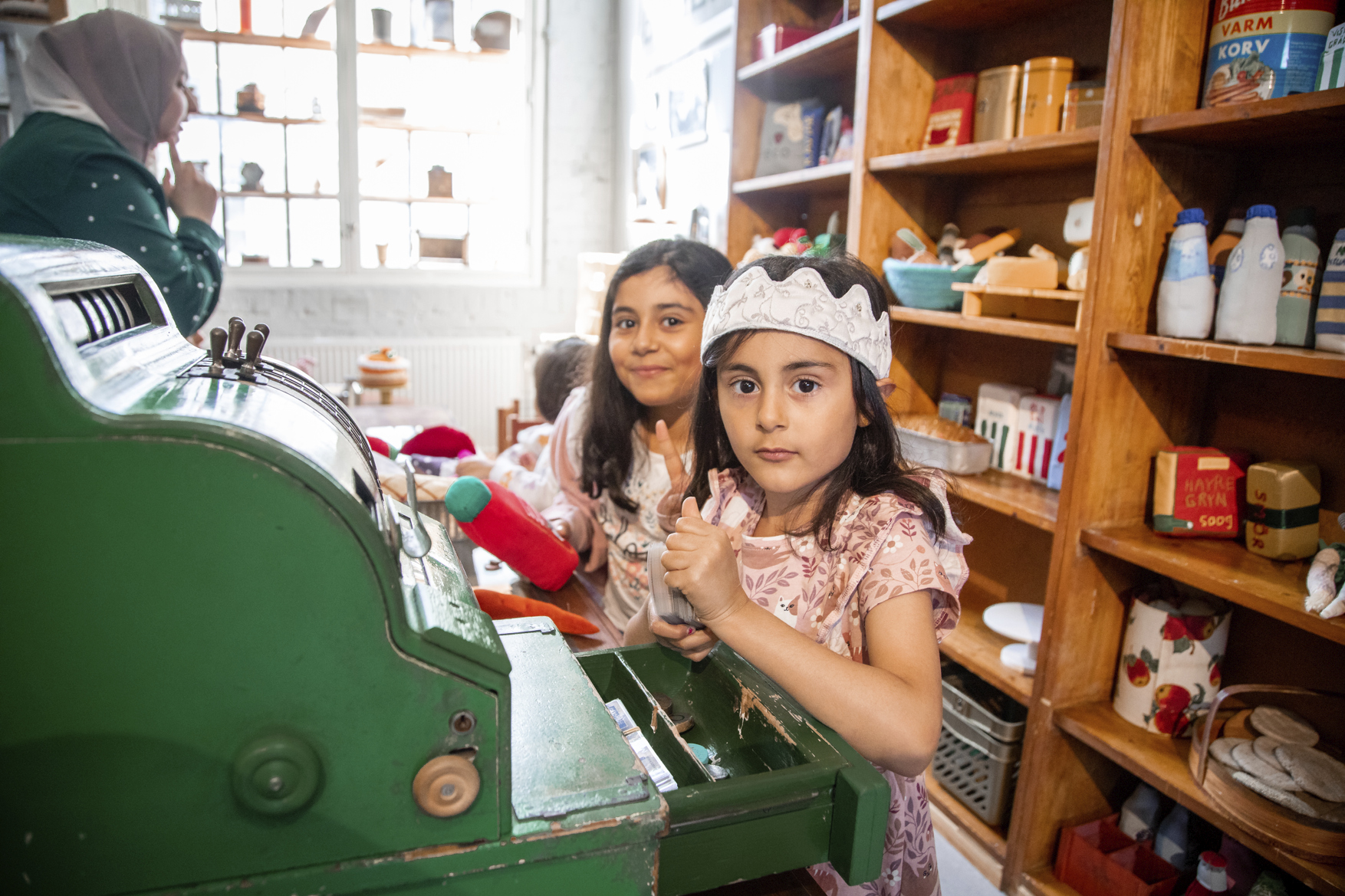 Two girls play business assistants in Tidaholm's Barnens hus. They are dressed as princesses.
