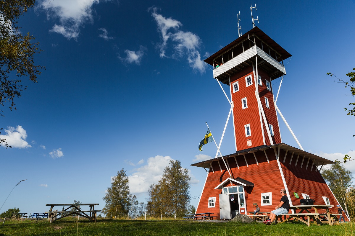 A red observation tower with a blue sky behind