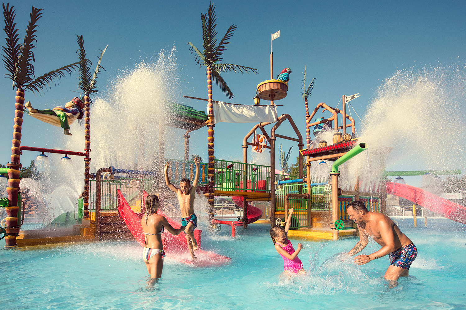 A family is playing and throwing water at each other in one of the pools at the water park Skara sommaland. 