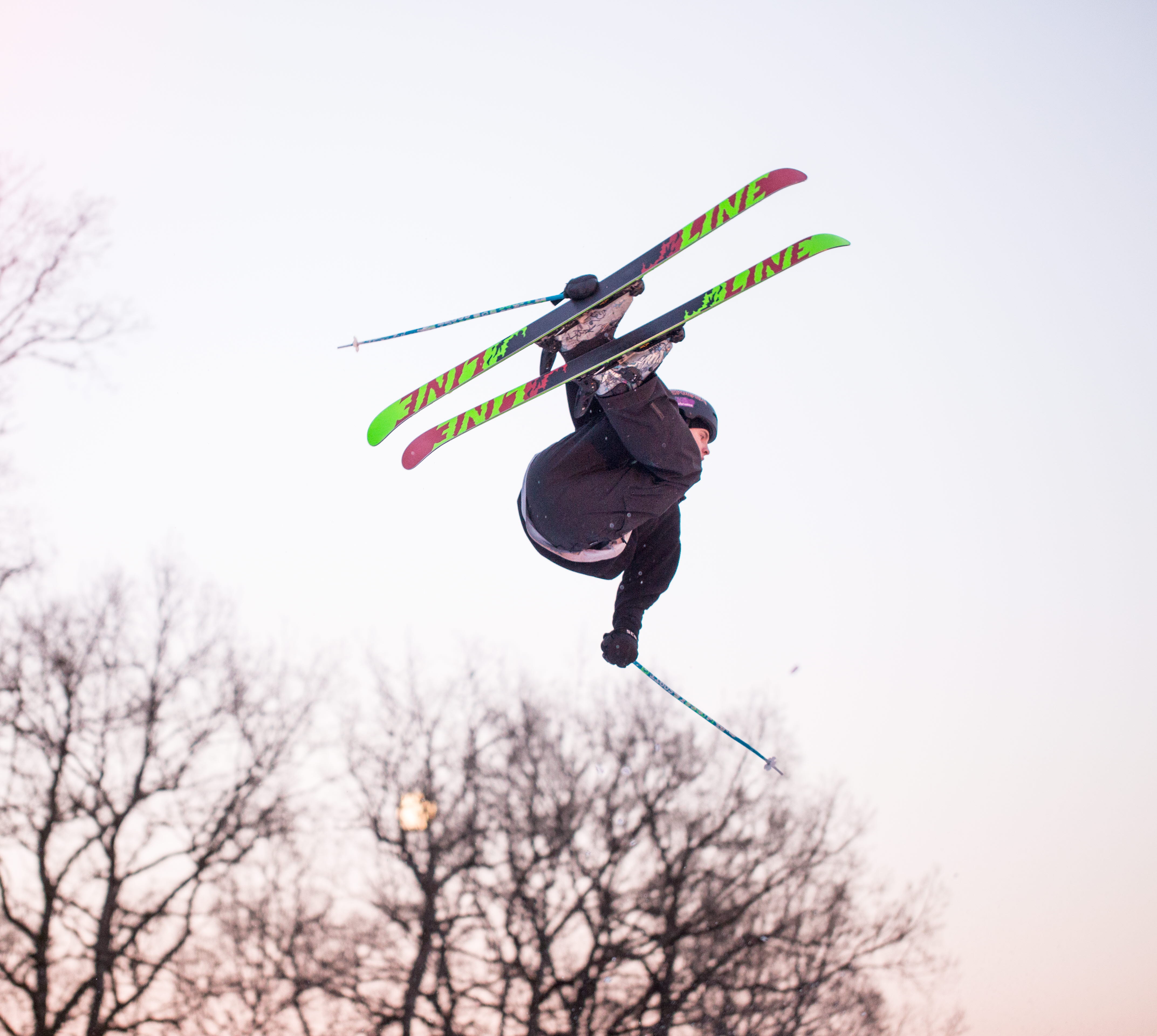 Family sitting by the fire surrounded by a winter landscape at Billingen moutain. Two girls are eating hot dogs. 