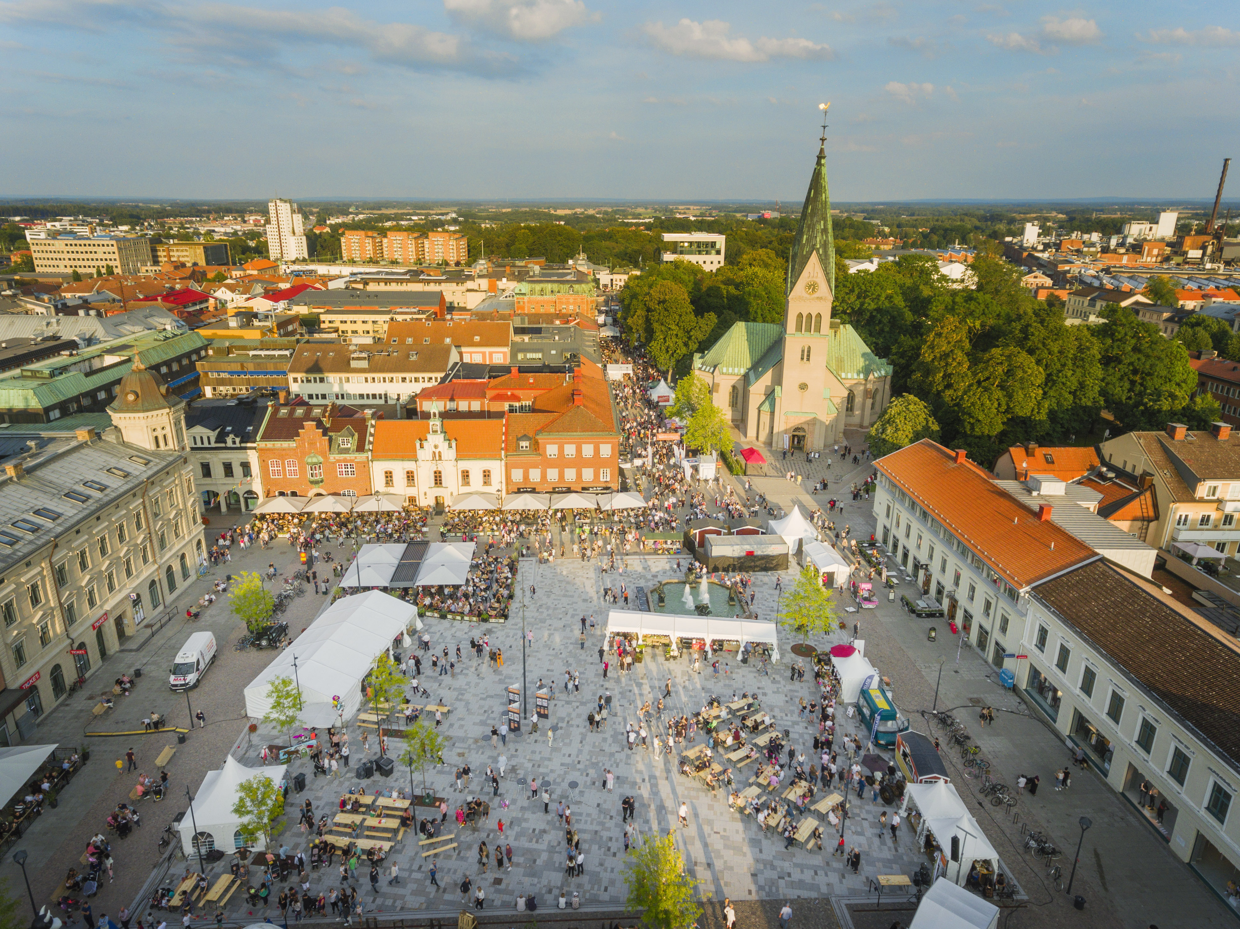 Drone picture of Hertig Johans Torg in Skövde Centrum during the Food Festival 2019. Beautiful city view with a blue sky and afternoon sun getting ready to set over the city.
