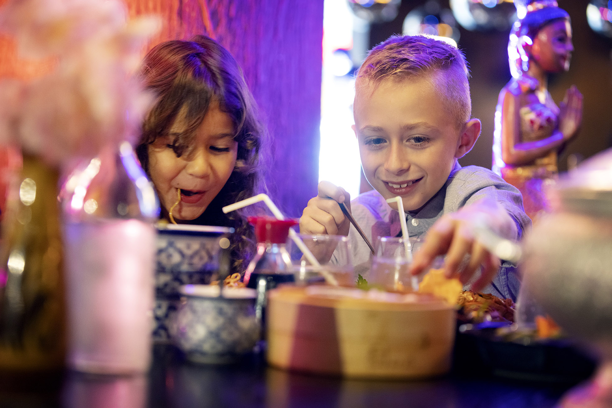 Two happy kids eating on a restaurant