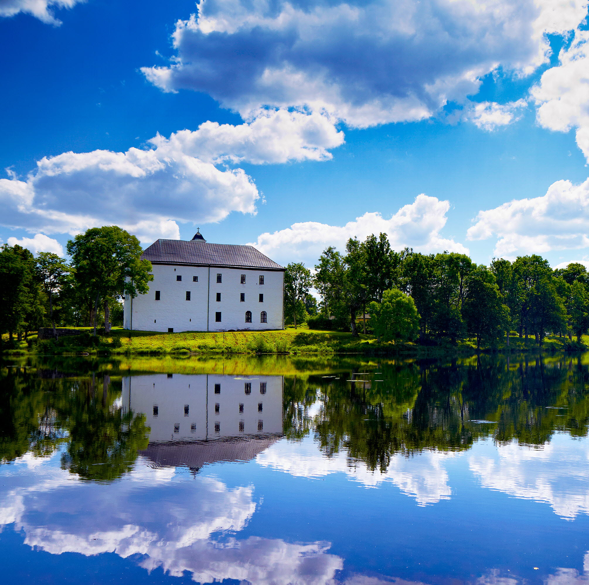 Barn och vuxen promenerar i solen mot Nordiska Akvarellmuseet