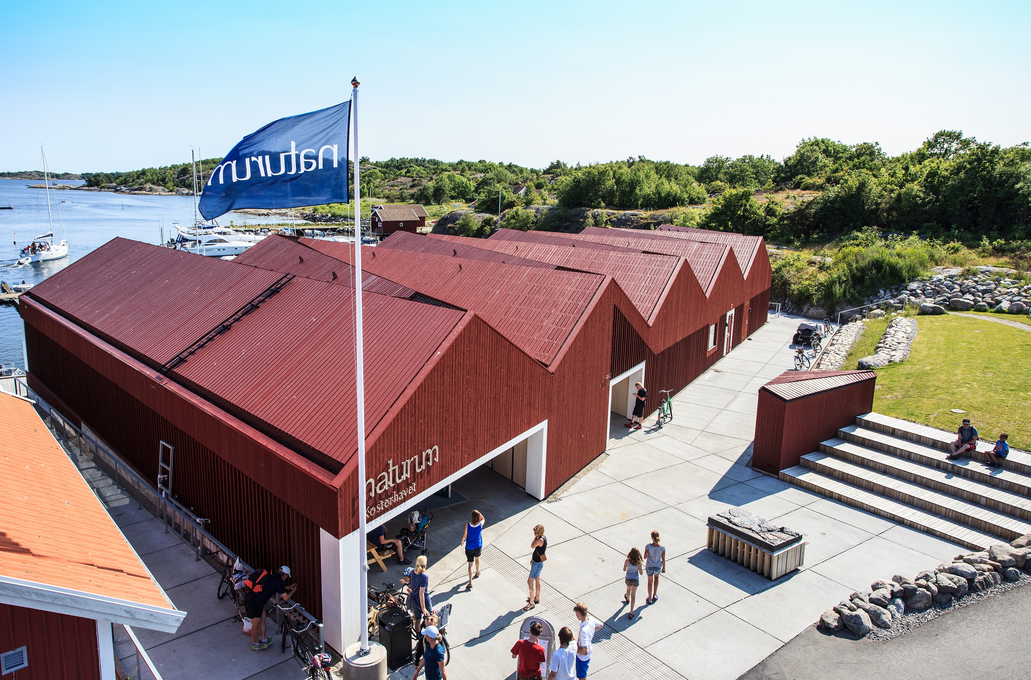 Building which houses the visitor centre Kosterhavet, In front of the entrance there are grass area and seating and the back is towards the sea.