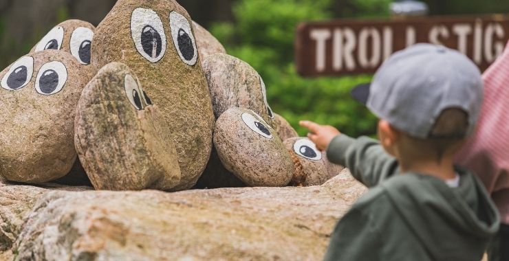 Children point to stone trolls