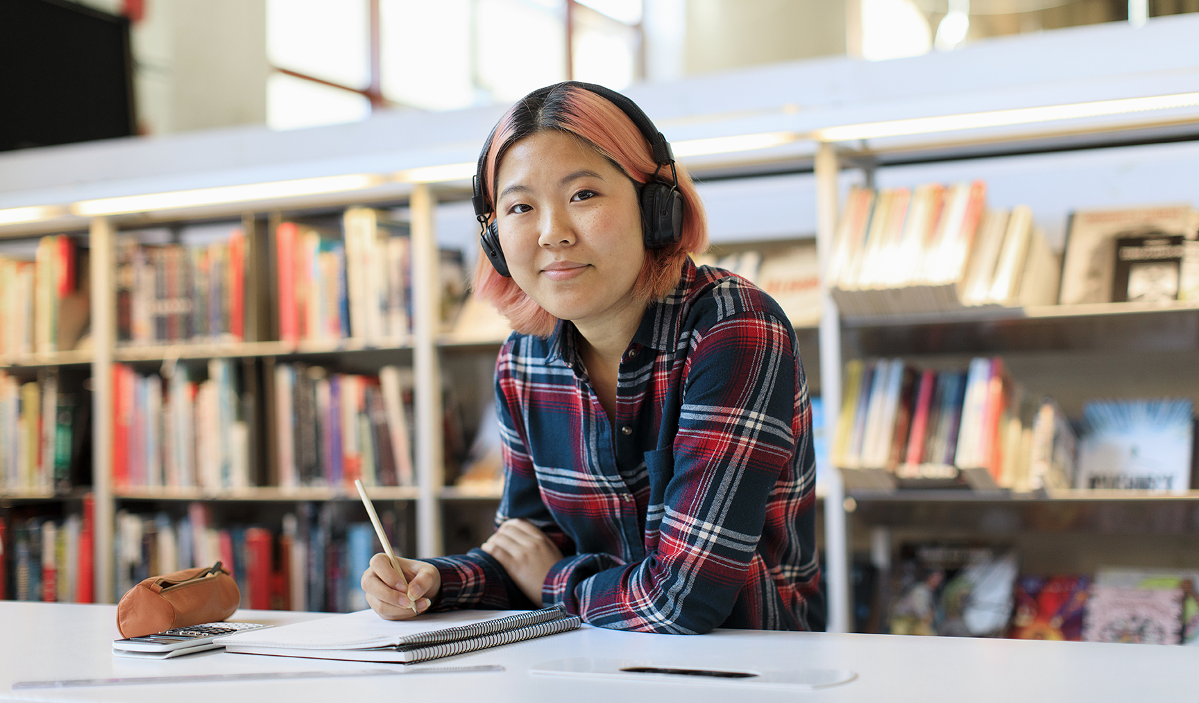 Bild på person som har hörlurar och sitter och skriver