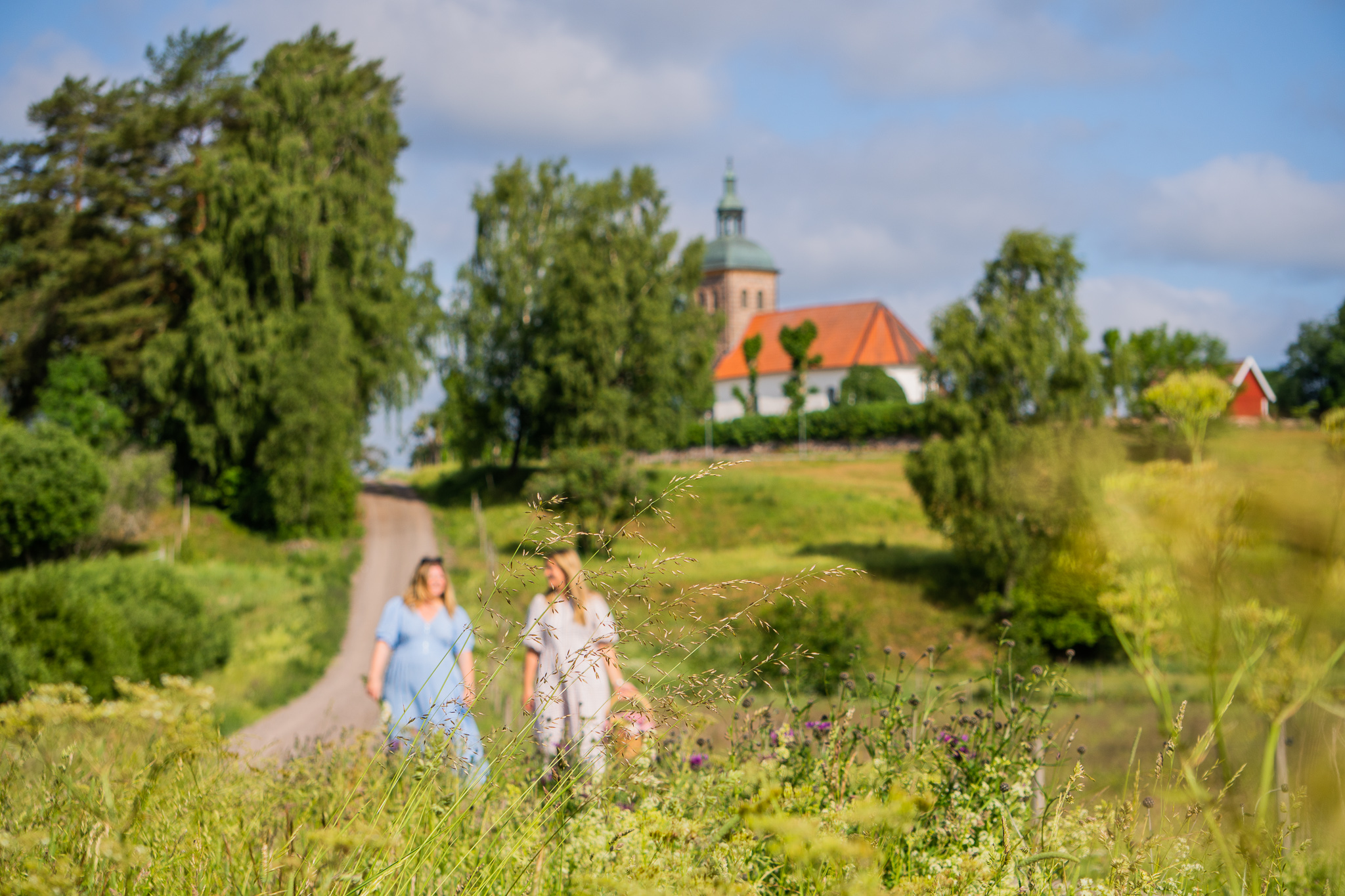 Two women walking on a road.