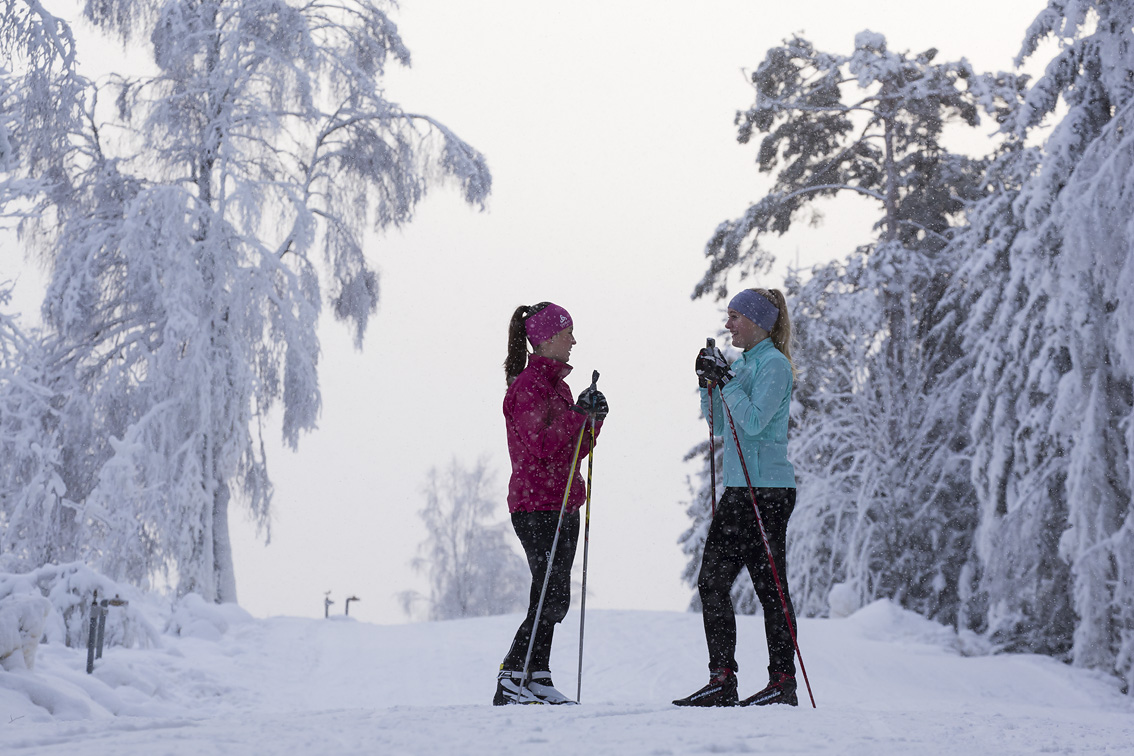 Two girls talking to each other in a winter landscape